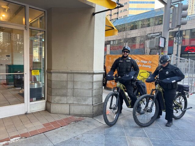 Denver Police Department officers James Harvey and Carrisa Rojas patrol the area of Denver's 16th Street Mall Tuesday. They are taking notes at 16th and California streets in front of a Jamba Juice where an airline attendant was stabbed to death Saturday night. (Carol McKinley/Denver Gazette)