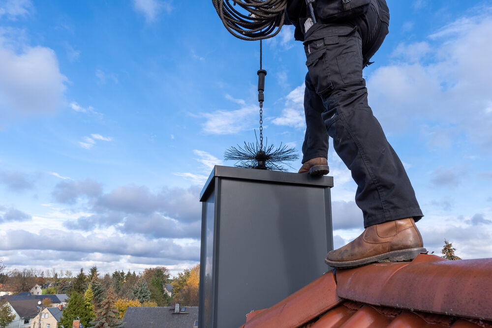 Chimney sweep on top of a house