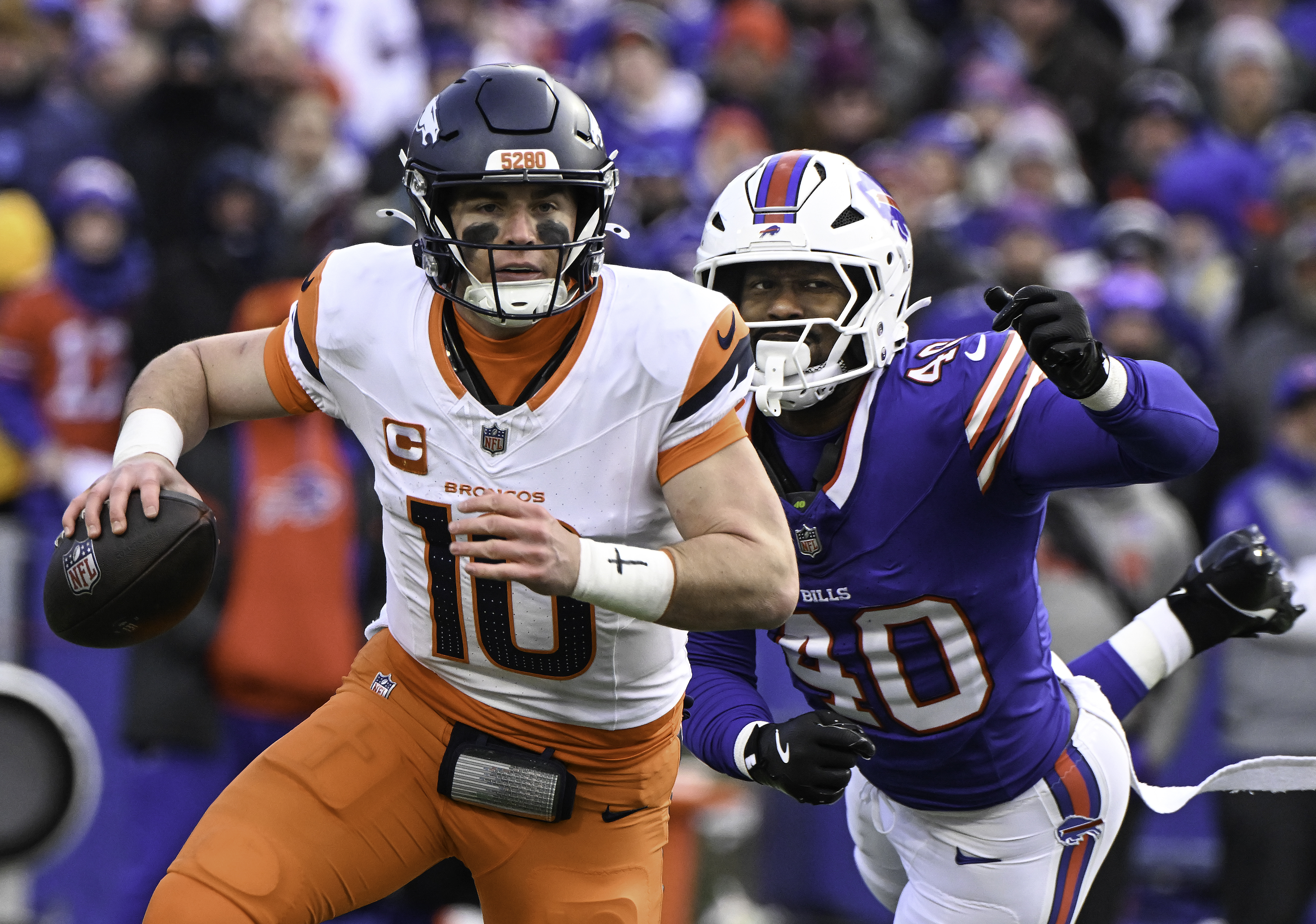 Denver Broncos quarterback Bo Nix (10) is chased former Broncos great and Buffalo Bills linebacker Von Miller (40) and outruns Miller in the fourth quarter at Highmark Stadium in Orchard Park, N.Y., on Jan. 12, 2025. The Broncos lost the AFC wild-card game 31-7. (Jerlee Bennett, The Gazette)