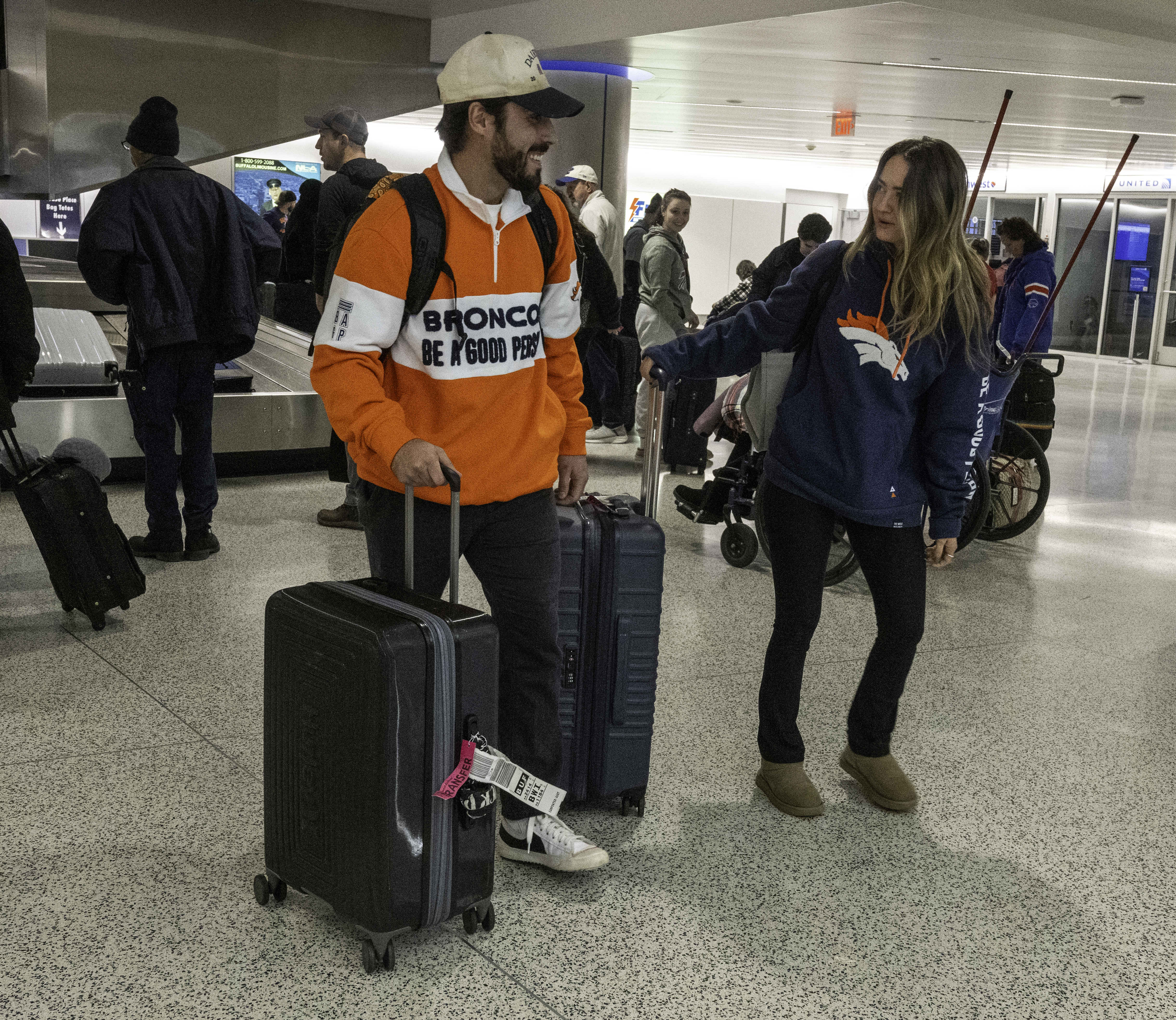 Broncos fans Austin Carpenter and Caileigh Schwartz were teenagers the last time the Broncos went to the playoffs and are now 27. They arrive at the Buffalo airport after traveling all day from Denver for the wildcard playoffs game between the Broncos and the Bills on Sunday.