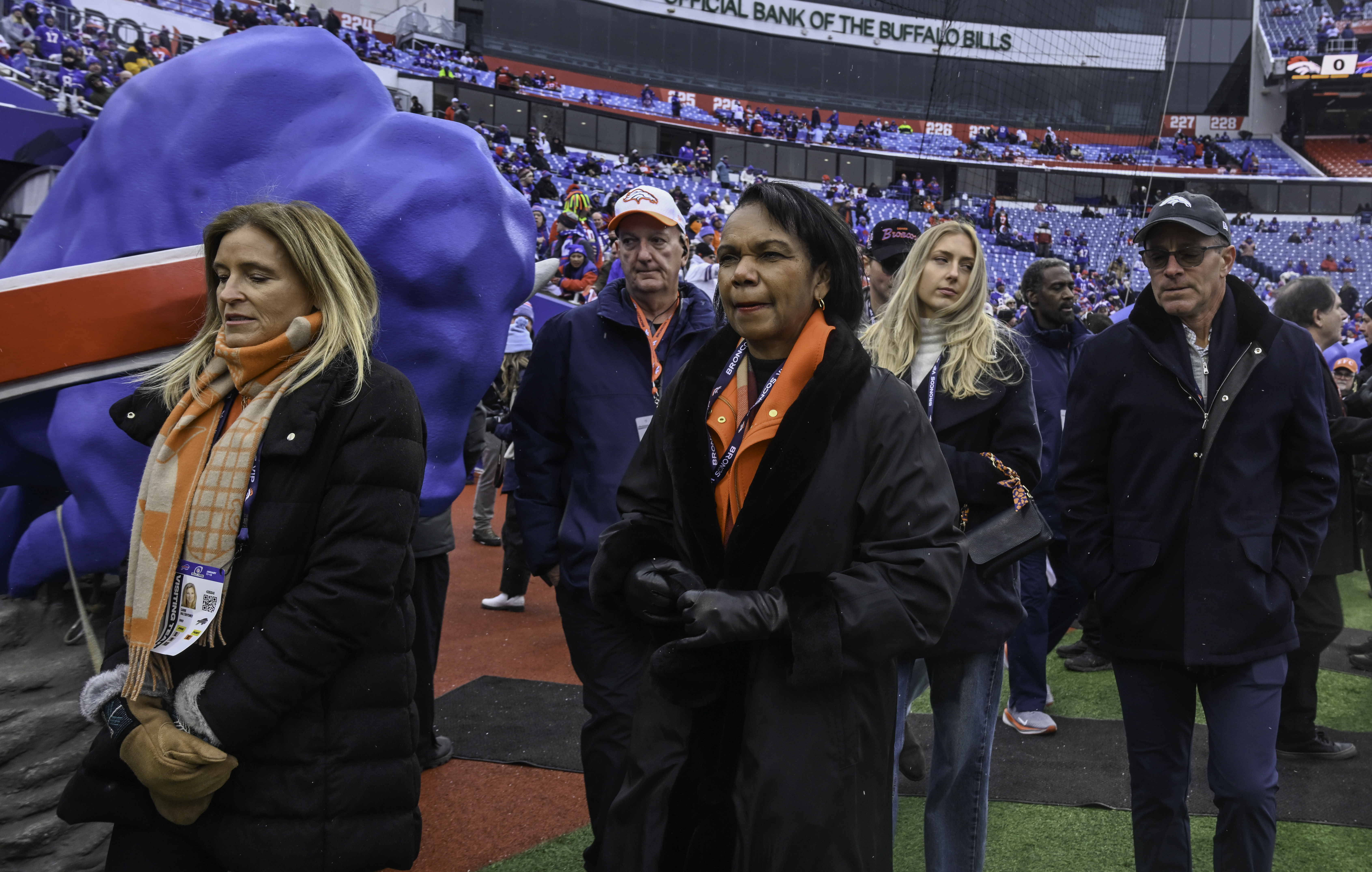 Broncos owners Carrie Penner, Condoleeza Rice (front left to right) and Greg Penner (far right) take to the field before the wild card playoff game between the Broncos and the Bills at Highmark Stadium in Buffalo on Sunday, Jan. 12, 2025. (Jerilee Bennett,The Gazette)