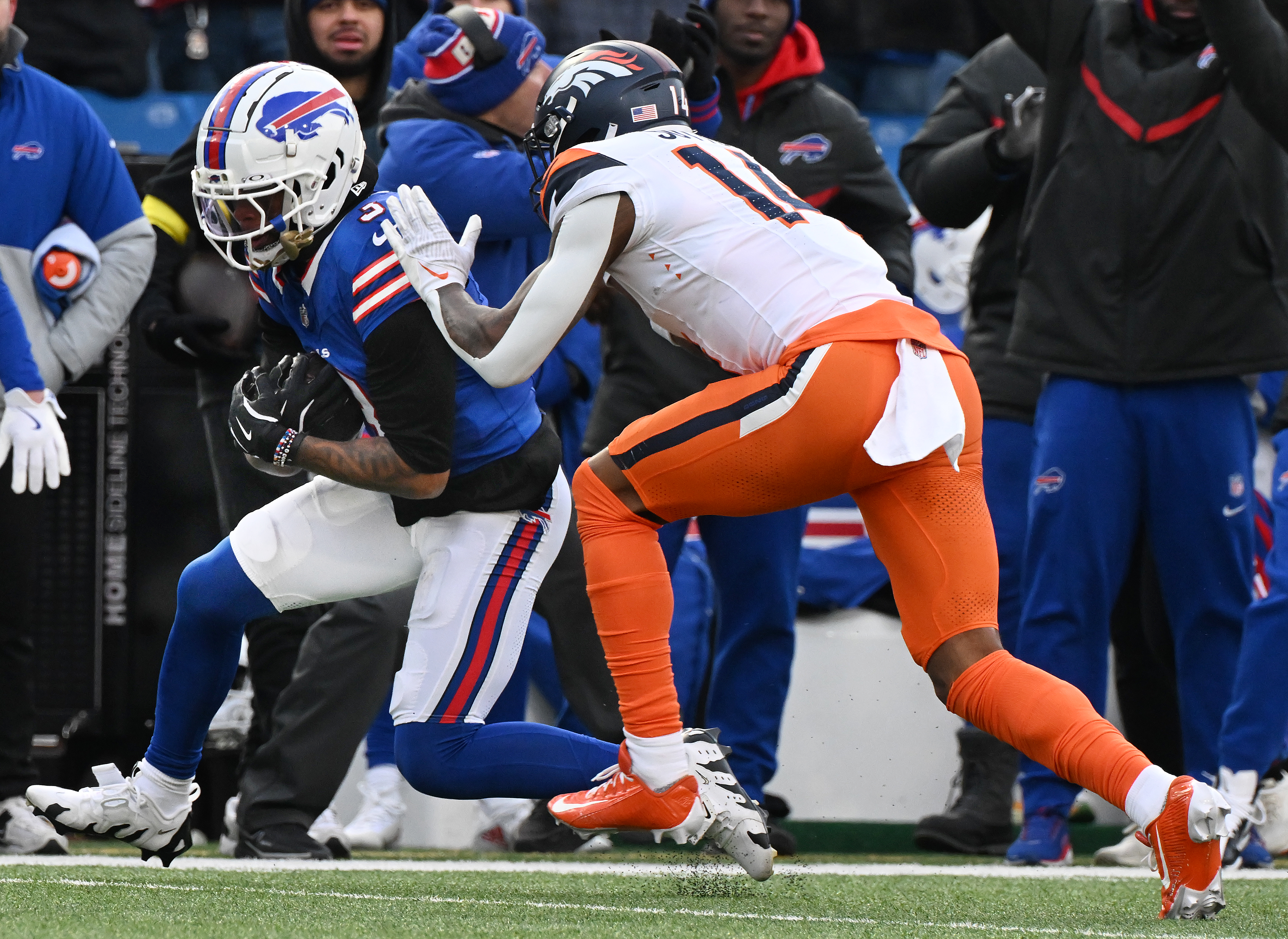 Denver Broncos wide receiver Courtland Sutton (14) goes after Buffalo Bills safety Damar Hamlin (3) after he intercepts the ball meant for Sutton in the 4th quarter of the wild card playoff game at Highmark Stadium in Buffalo on Sunday, Jan. 12, 2025. The Broncos lost 31-7. (Jerilee Bennett,The Gazette)
