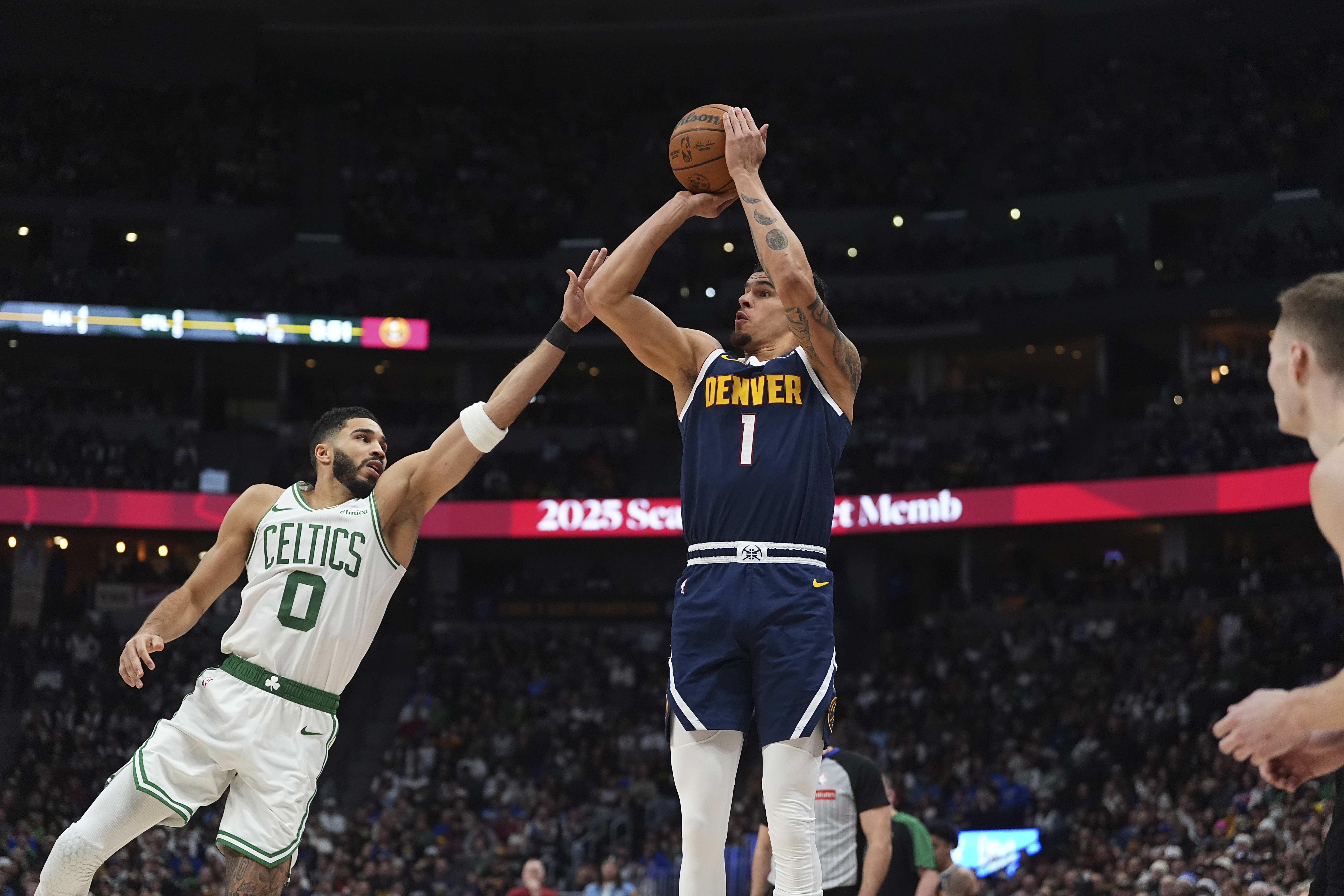 Denver Nuggets forward Michael Porter Jr. (1) and Boston Celtics forward Jayson Tatum (0) in the second half of an NBA basketball game Tuesday, Jan. 7, 2025, in Denver. (AP Photo/David Zalubowski) (David Zalubowski)