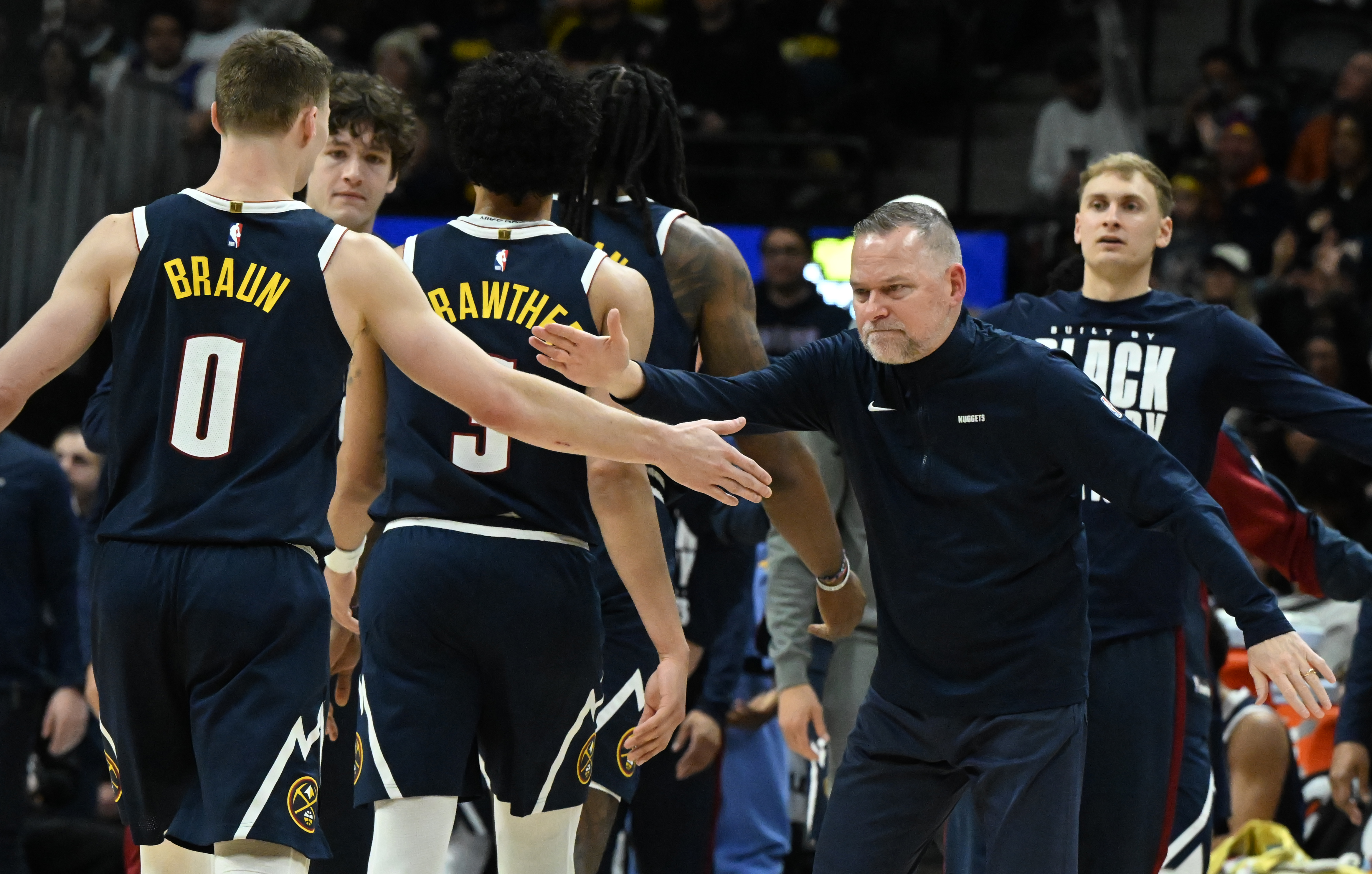 Denver Nuggets Head Coach Michael Malone comes out to greet Denver Nuggets guard Christian Braun (0) and other Nuggets during a timeout in the second quarter of a game at Ball Arena on Wednesday, Feb. 12, 2025. (Jerilee Bennett,The Gazette)