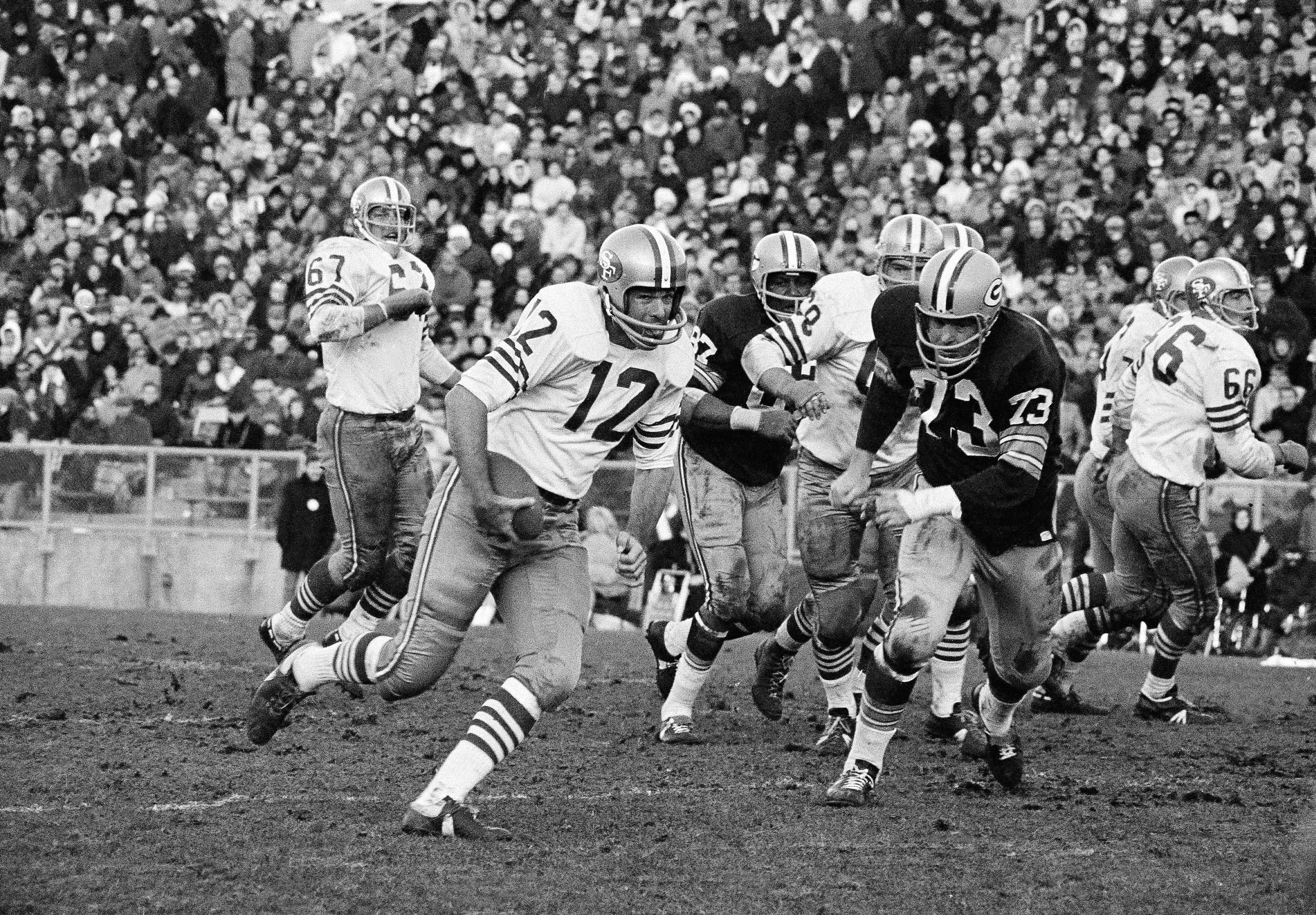 Green Bay Packers defense rushes San Francisco 49ers quarterback John Brodie (12) in second half of game, Nov. 20, 1967, Green Bay, Wisc. Brodie failed to make first down and 49ers had to give up ball. Packers Jim Weatherwax (73) helped make tackle. Packers overcame 49ers, 13-0. The rest of the players are unidentified. (AP Photo/Paul Shane) (Paul Shane)