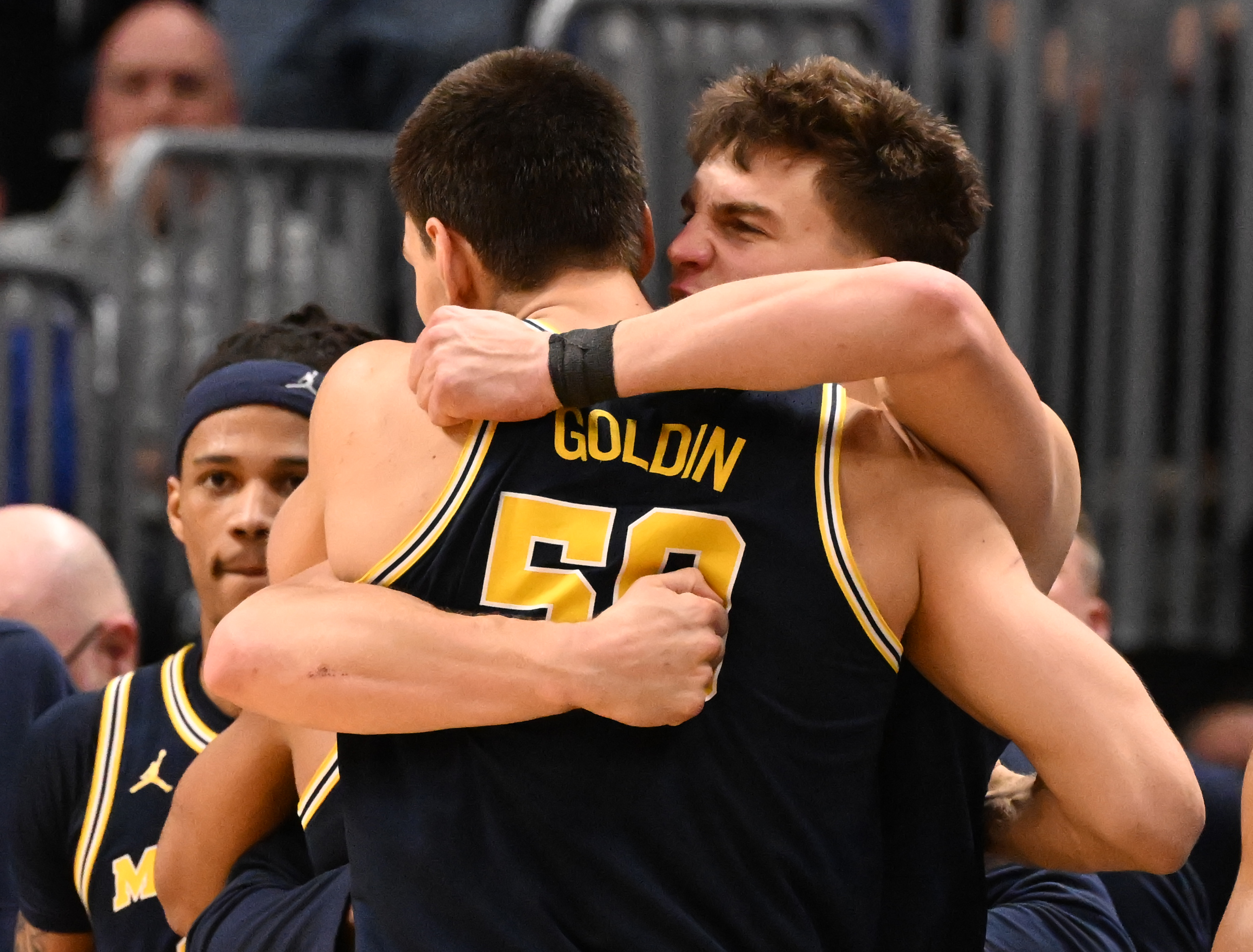 Michigan Wolverines center Vladislav Goldin (50) gets a big hug from Michigan Wolverines forward Will Tschetter (42) after the game of the second round of March Madness at Ball Arena on Saturday, March 22, 2025. Michigan won the game 91-79 and will be going to the Sweet Sixteen. (Jerilee Bennett,The Gazette)