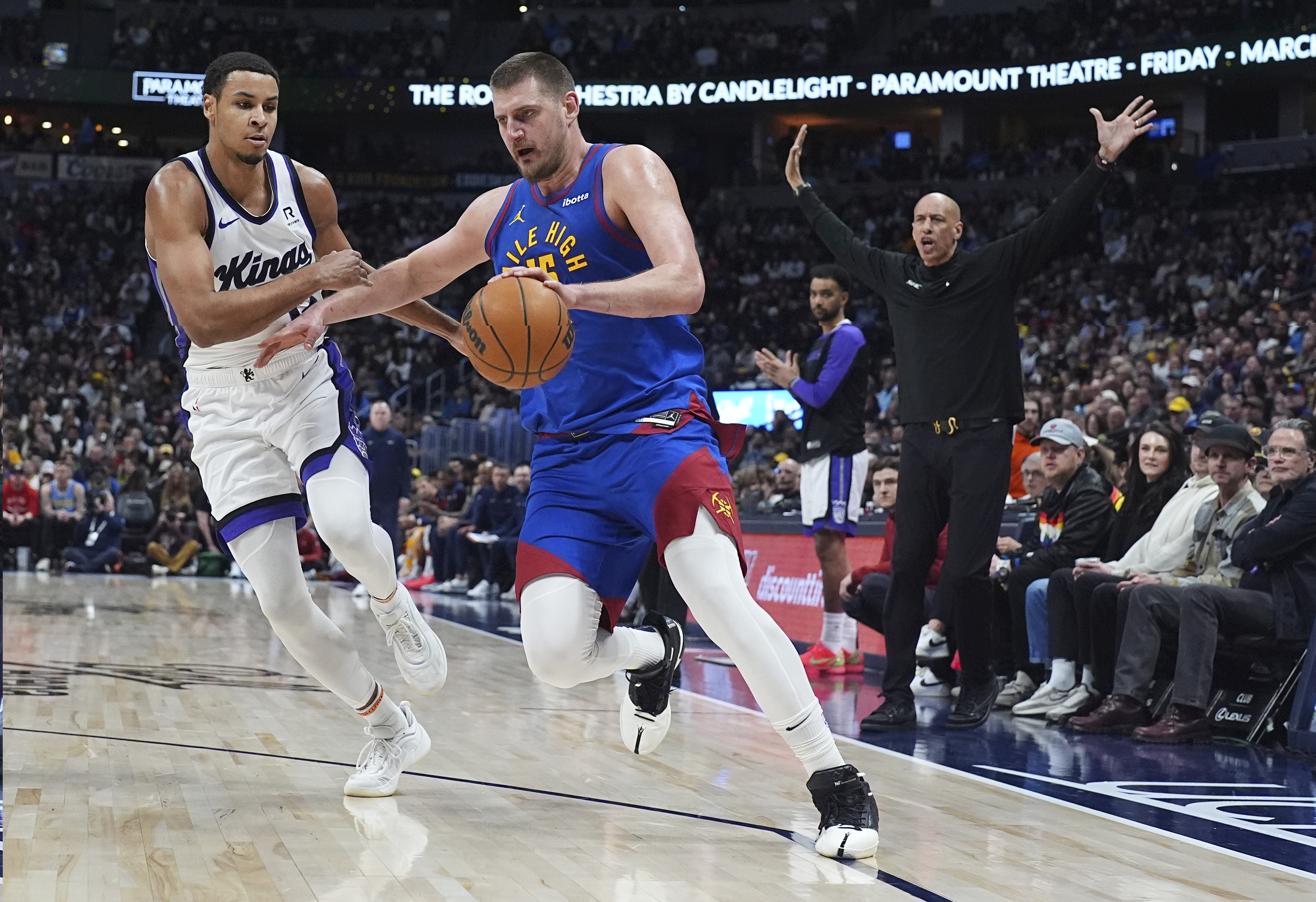 Denver Nuggets center Nikola Jokic, center, drives past Sacramento Kings forward Keegan Murray, left, as head coach Doug Christie looks on in the second half of an NBA basketball game Wednesday, March 5, 2025, in Denver. (AP Photo/David Zalubowski) (David Zalubowski)