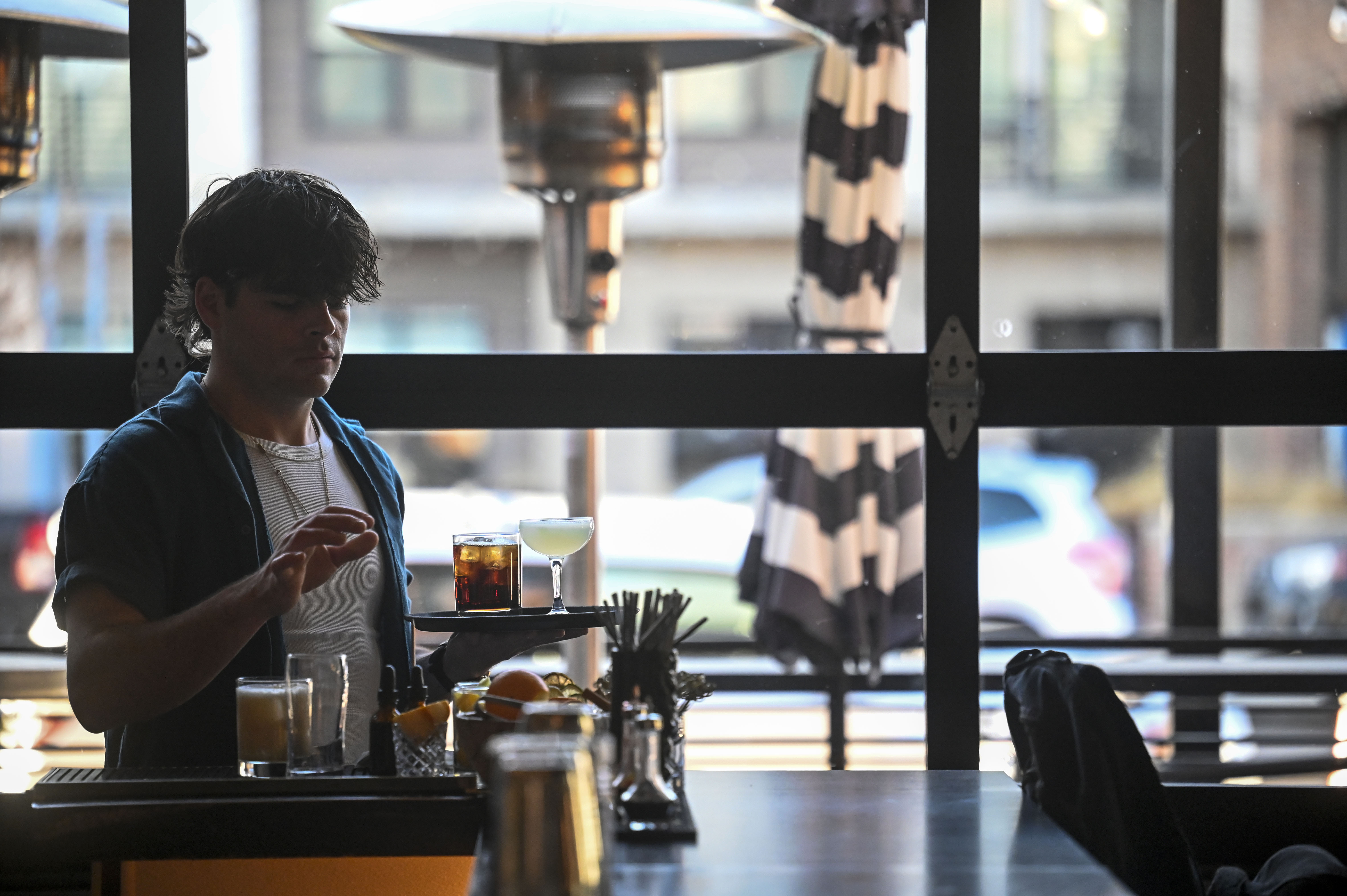 Easton Adams, a server at The Greenwich, carries a drink upstairs to a customer during a shift in Denver's RiNo neighborhood on Friday, Feb. 28, 2025. (Stephen Swofford, Denver Gazette) (StephenSwoffordPhotographerstephen.swofford@gazette.comhttps://secure.gravatar.com/avatar/1ddcaf11c5d70eaa58546ddc4e038687?d=mm&r=g)