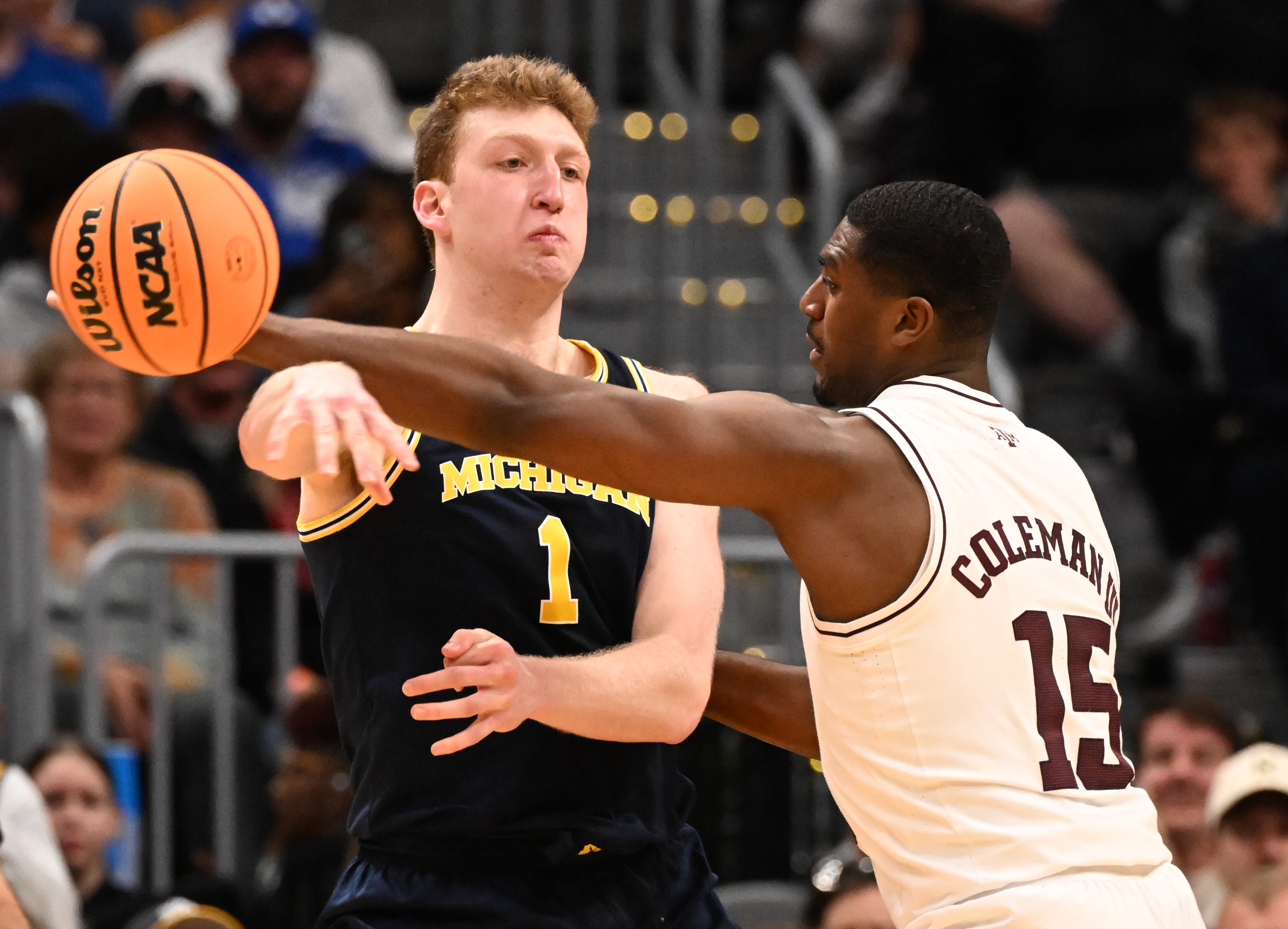 Michigan Wolverines center Danny Wolf (1) passes the ball past Texas A&M Aggies forward Henry Coleman III (15) during the second half of the second round of March Madness at Ball Arena on Saturday, March 22, 2025. Michigan won the game 91-79 and will be going to the Sweet Sixteen. (Jerilee Bennett,The Gazette)