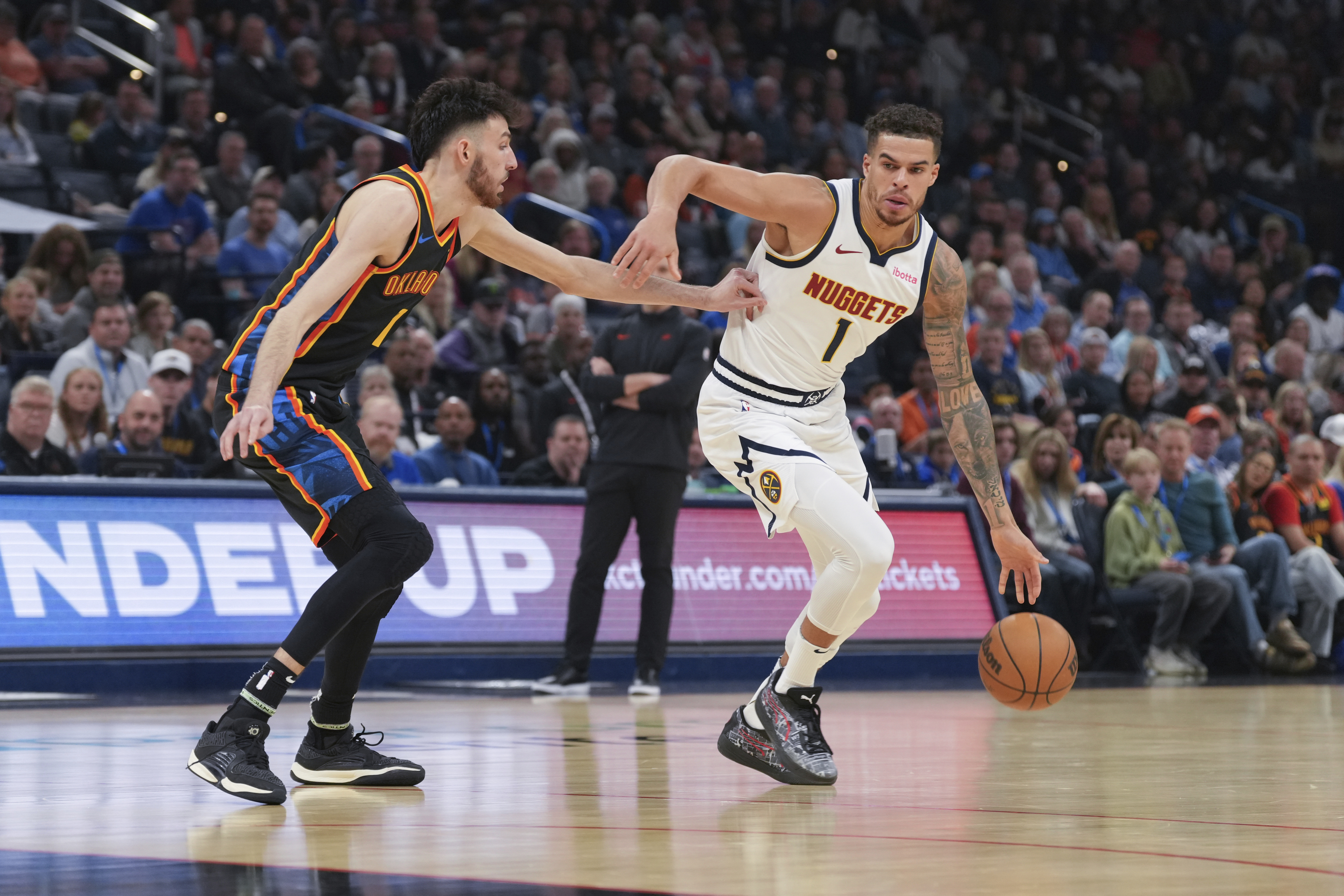 Denver Nuggets guard Michael Porter Jr., right, drives past Oklahoma City Thunder forward Chet Holmgren, left, during the first half of an NBA basketball game, Sunday, March 9, 2025, in Oklahoma City. (AP Photo/Kyle Phillips) (Kyle Phillips)