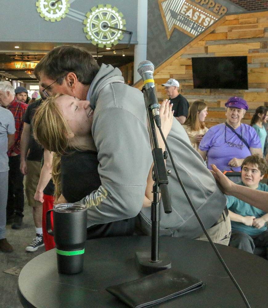 Former CU football star Ed Reinhardt receives a hug from a castmate at rehearsal for the group's upcoming 2025 pop-music revue. (JOHN MOORE/DENVER GAZETTE)