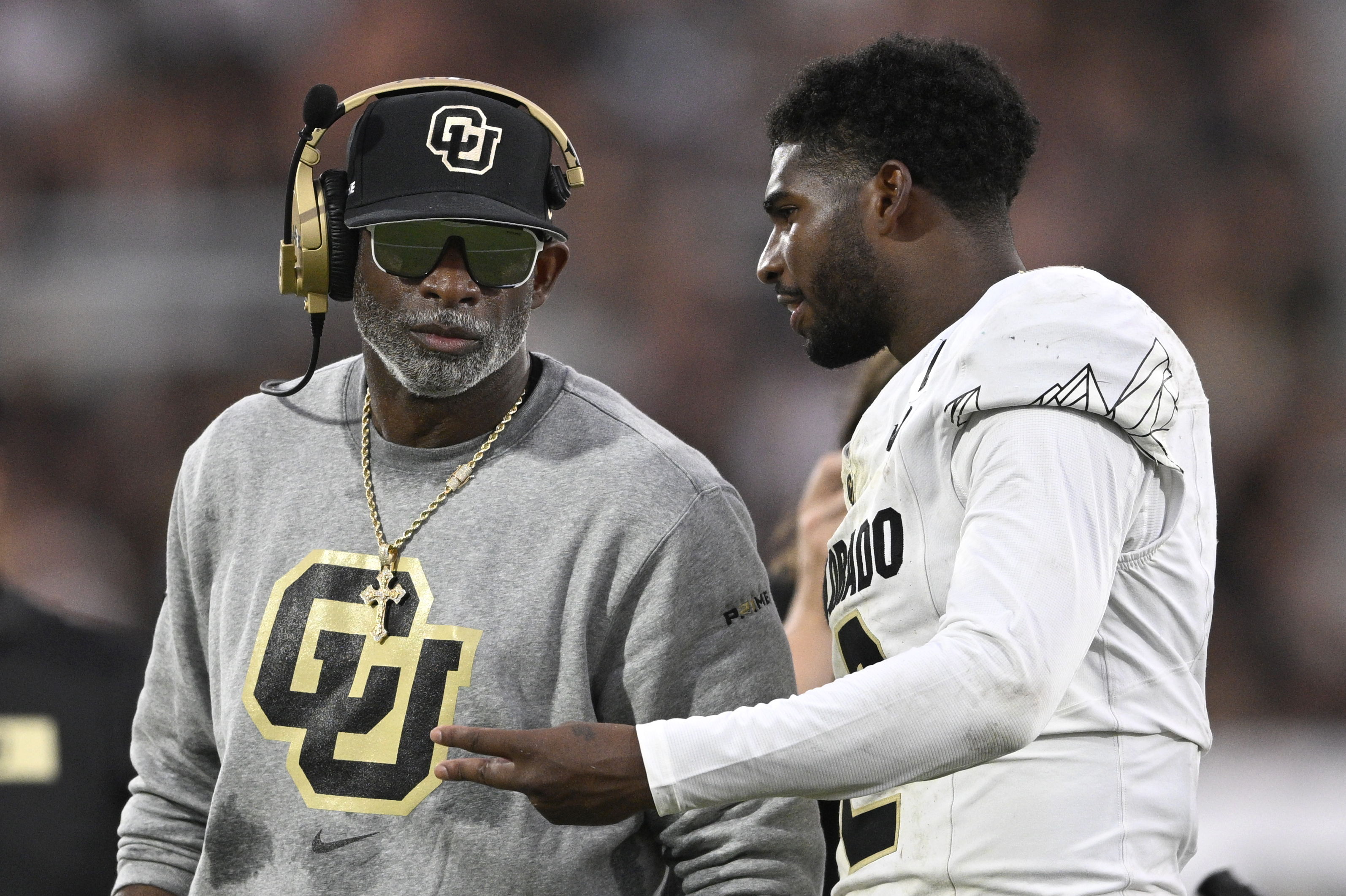 Colorado head coach Deion Sanders, left, talks with quarterback Shedeur Sanders during a timeout in the second half of a game against Central Florida on Sept. 28 in Orlando, Fla. (The Associated Press)