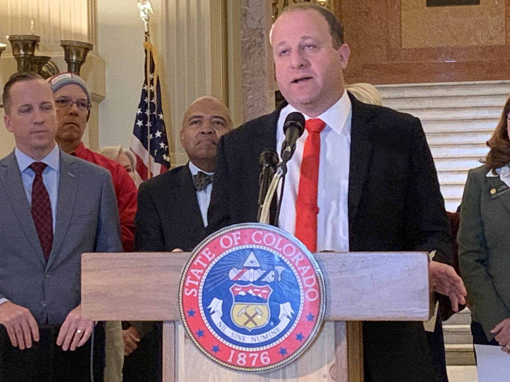 In this file photo, Gov. Jared Polis announces 2020 premiums for families who buy their own health insurance will drop by an average of 20.2% as compared to 2019 rates. ((Photo by Marianne Goodland, Colorado Politics))