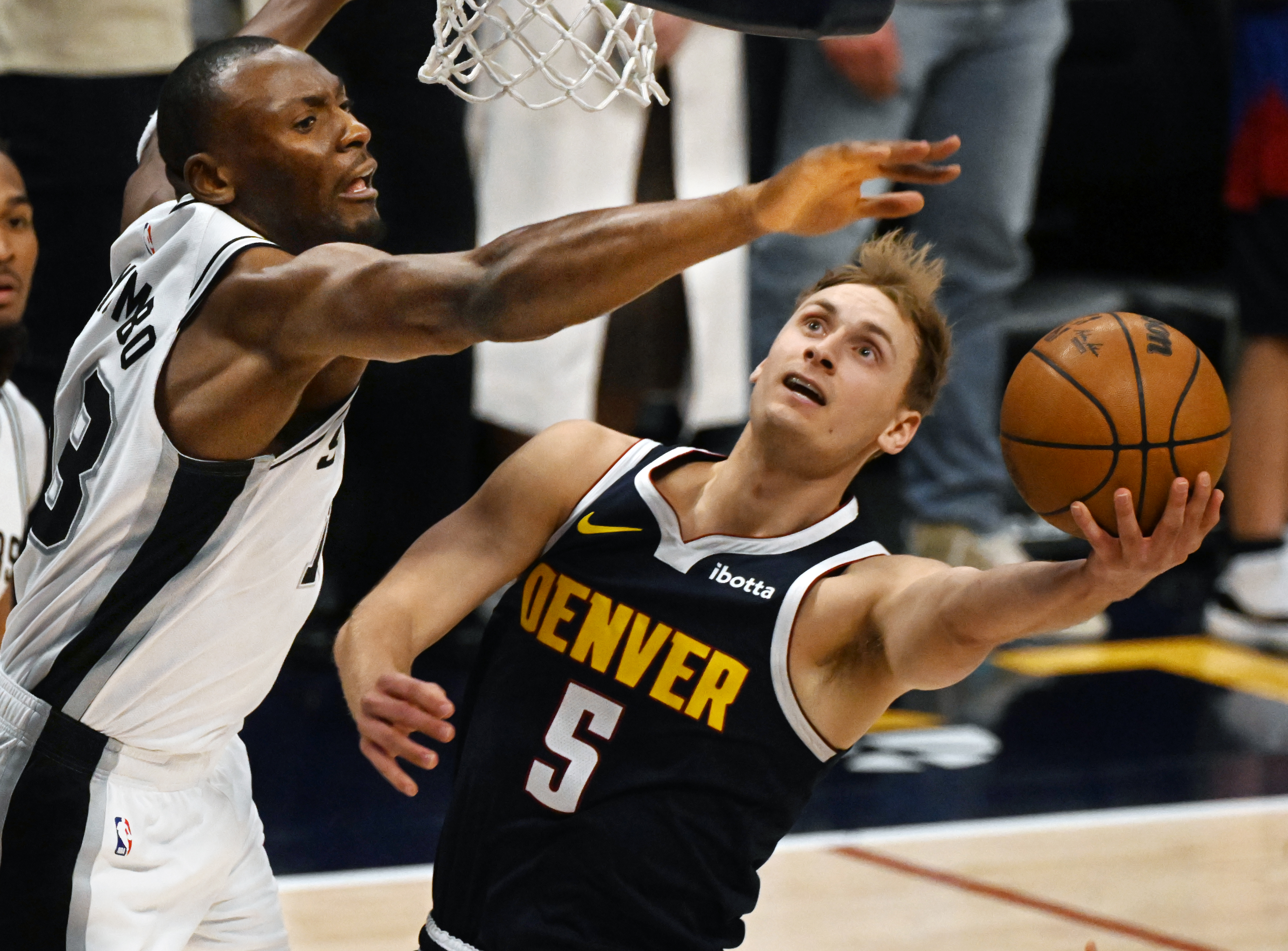 Nuggets Hunter Tyson is defended by Spurs Bismack Biyombo on the way to scoring a basket in the 1st quarter during a game at Ball Arena on Wednesday, April 2, 2025. (Jerilee Bennett,The Gazette)