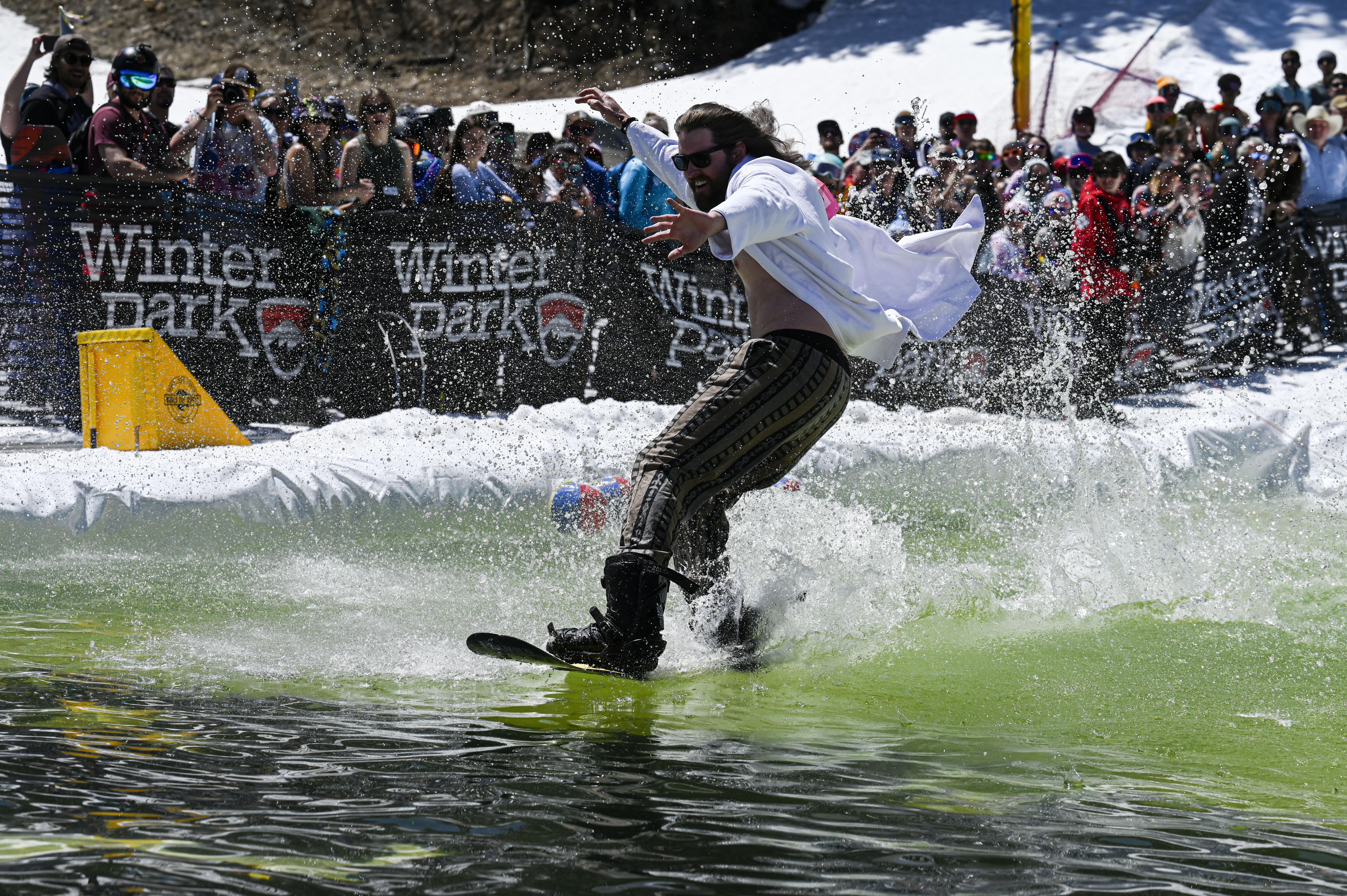 A competitor snowboards across a pool of water at the base of Winter Park during the Spring Splash event to celebrate the last day of the season on Sunday, April 27, 2025 (Stephen Swofford, Denver Gazette) (StephenSwoffordPhotographerstephen.swofford@gazette.comhttps://secure.gravatar.com/avatar/1ddcaf11c5d70eaa58546ddc4e038687?d=mm&r=g)
