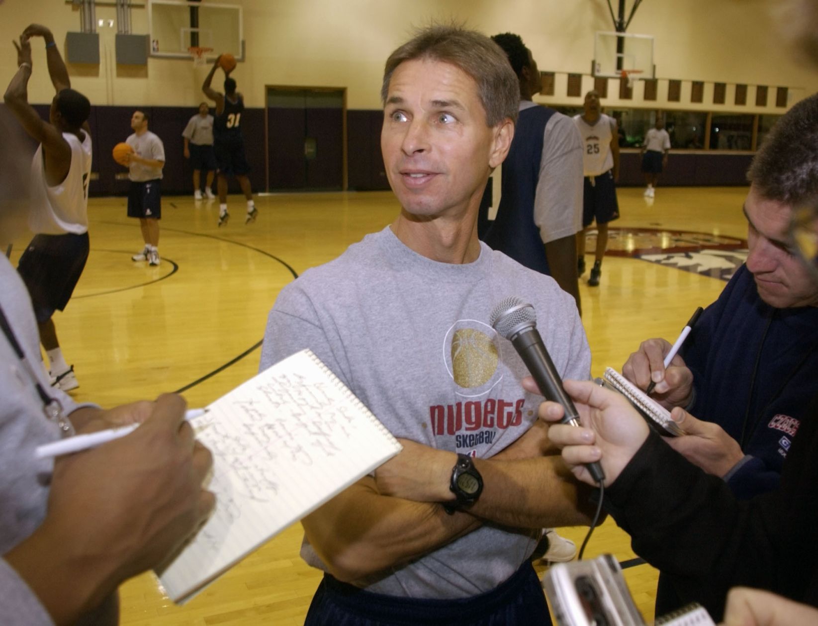 Denver Nuggets head coach Jeff Bzdelik, center, jokes with reporters during a break in the team's practice in the Pepsi Center on Wednesday, Oct. 2, 2002. Bzdelik was heading only his second practice since taking over the team's head job just weeks ago. (AP Photo/David Zalubowski) (David Zalubowsk/AP)