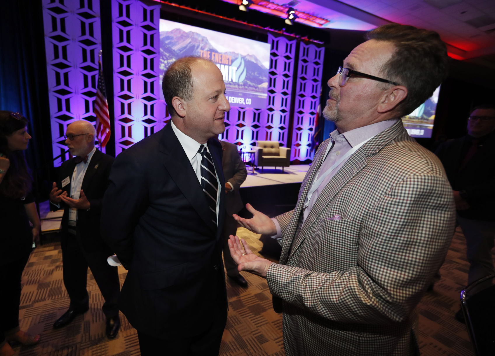 Colorado Gov. Jared Polis, left, listens as David Keyte of Caerus Oil and Gas of Denver makes a point at The Energy Summit, which was staged by Colorado Oil and Gas Association, Wednesday, Aug. 28, 2019, in Denver. Polis was questioned about new rules that he signed into law that increase regulations on the industry. (AP Photo/David Zalubowski) (David Zalubowski)