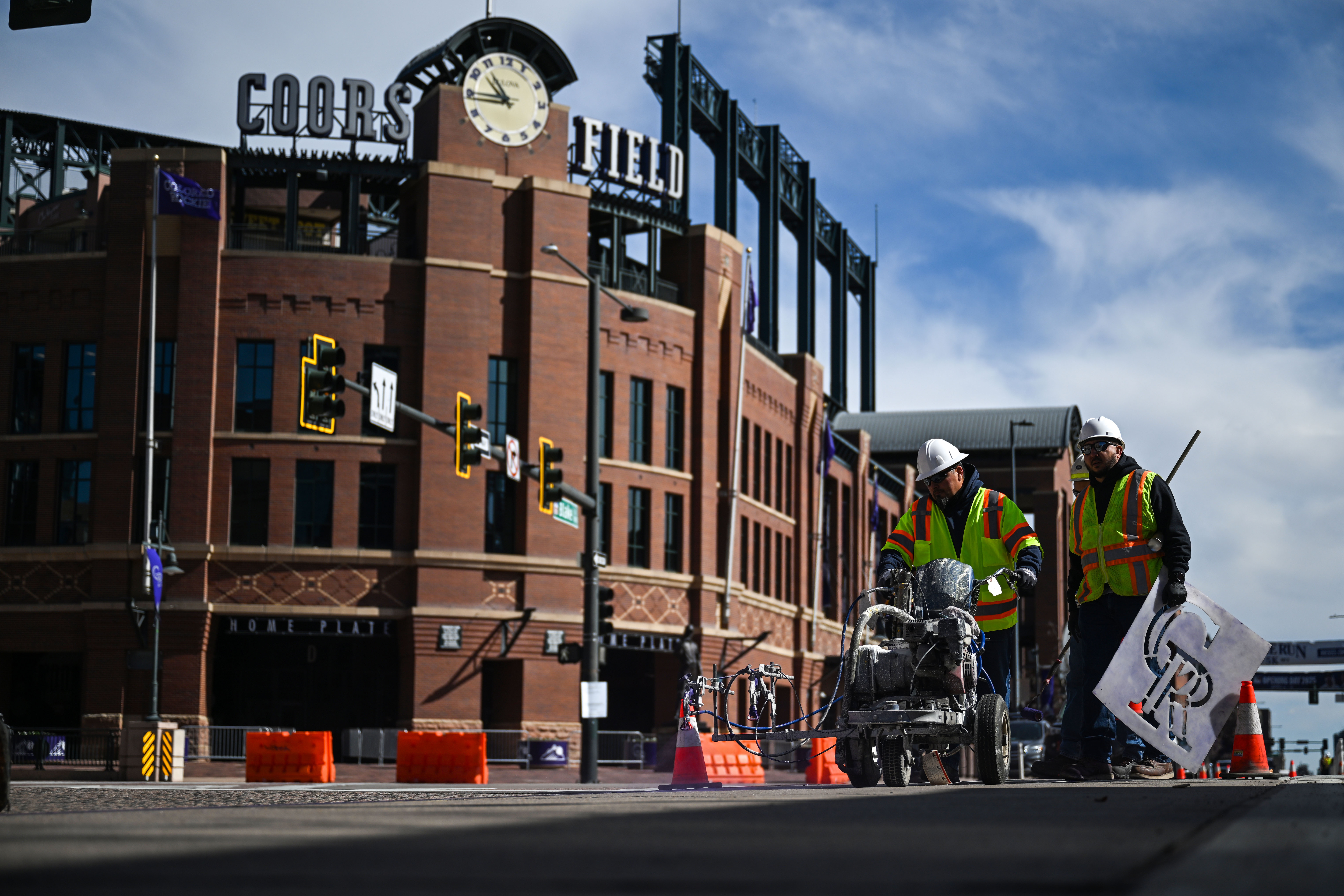 Jason Lujan, left, and Alfredo Corrugedo paint a purple stripe down Blake Street near Coors Field on Wednesday, April 2, 2025 as they help prepare for the Rockies home opener on Friday. (Stephen Swofford, The Denver Gazette) (Stephen Swofford/ Denver Gazette)