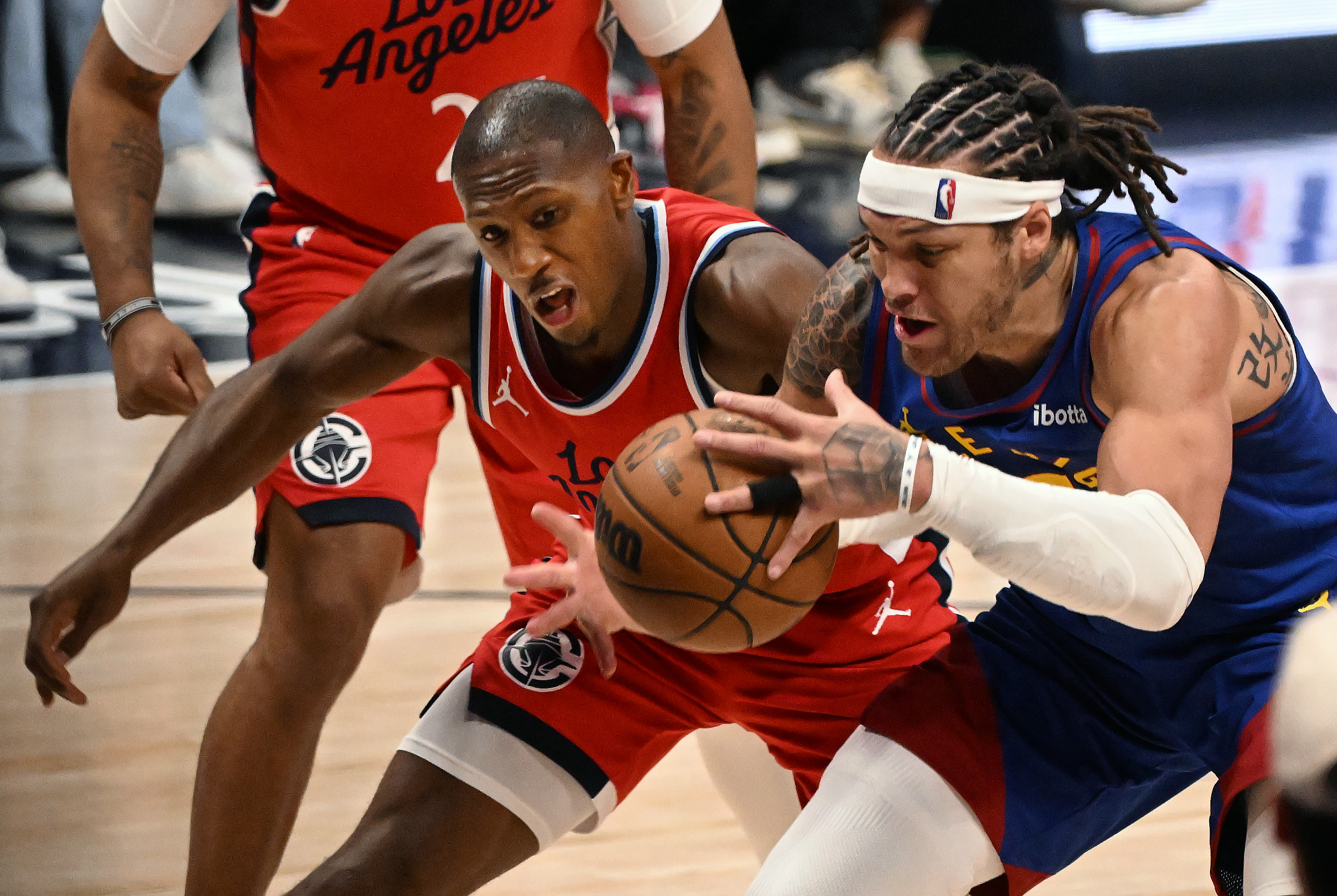 Nuggets Aaron Gordon and Cliippers Kris Dunn fight for the ball in overtime of the first series of the NBA playoffs at Ball Arena on Saturday, April 19, 2025. The Nuggets won the game in overtime 112-110. (Jerilee Bennett,The Gazette)