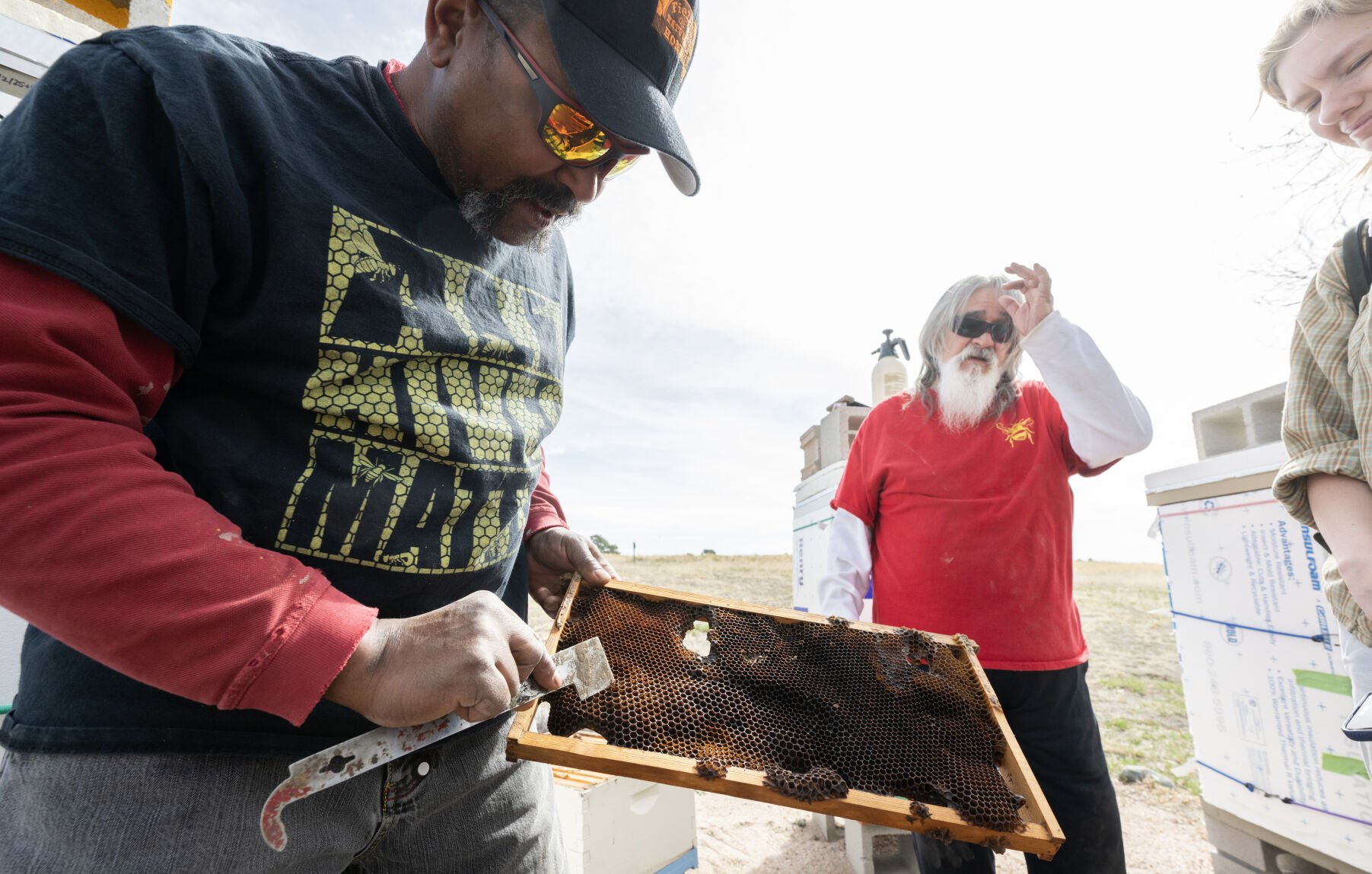 Lazarus Fields checks the combs of a hive on Angela Kataza’s property east of Colorado Springs on Friday, March 28, 2025, while Frankie Bailey looks on. (The Gazette, Christian Murdock) (Christian Murdock, The Gazette)