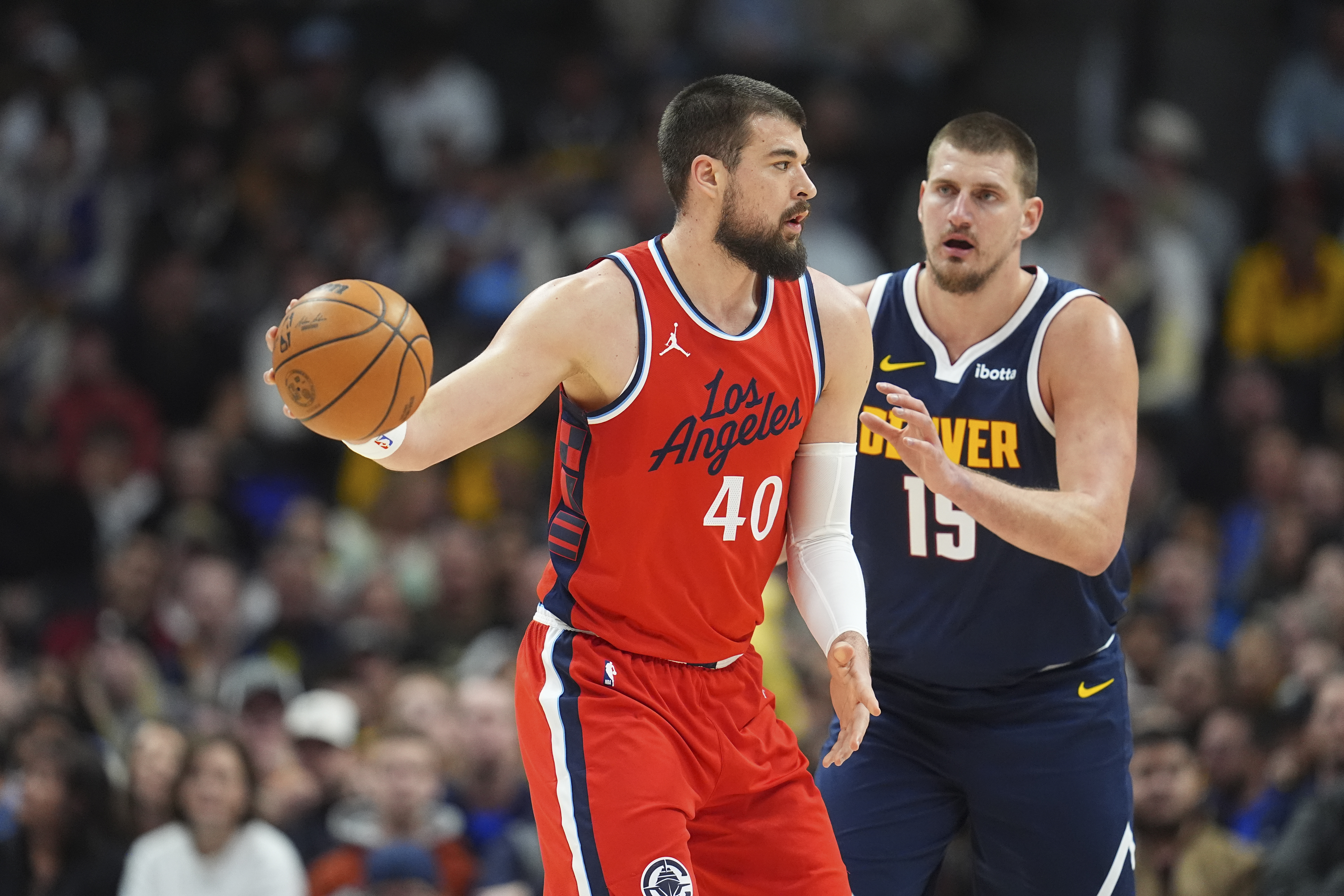 Los Angeles Clippers center Ivica Zubac (40) looks to pass the ball as Denver Nuggets center Nikola Jokic (15) defends in the first half of an NBA basketball game Friday, Dec. 13, 2024, in Denver. (AP Photo/David Zalubowski) (David Zalubowski)