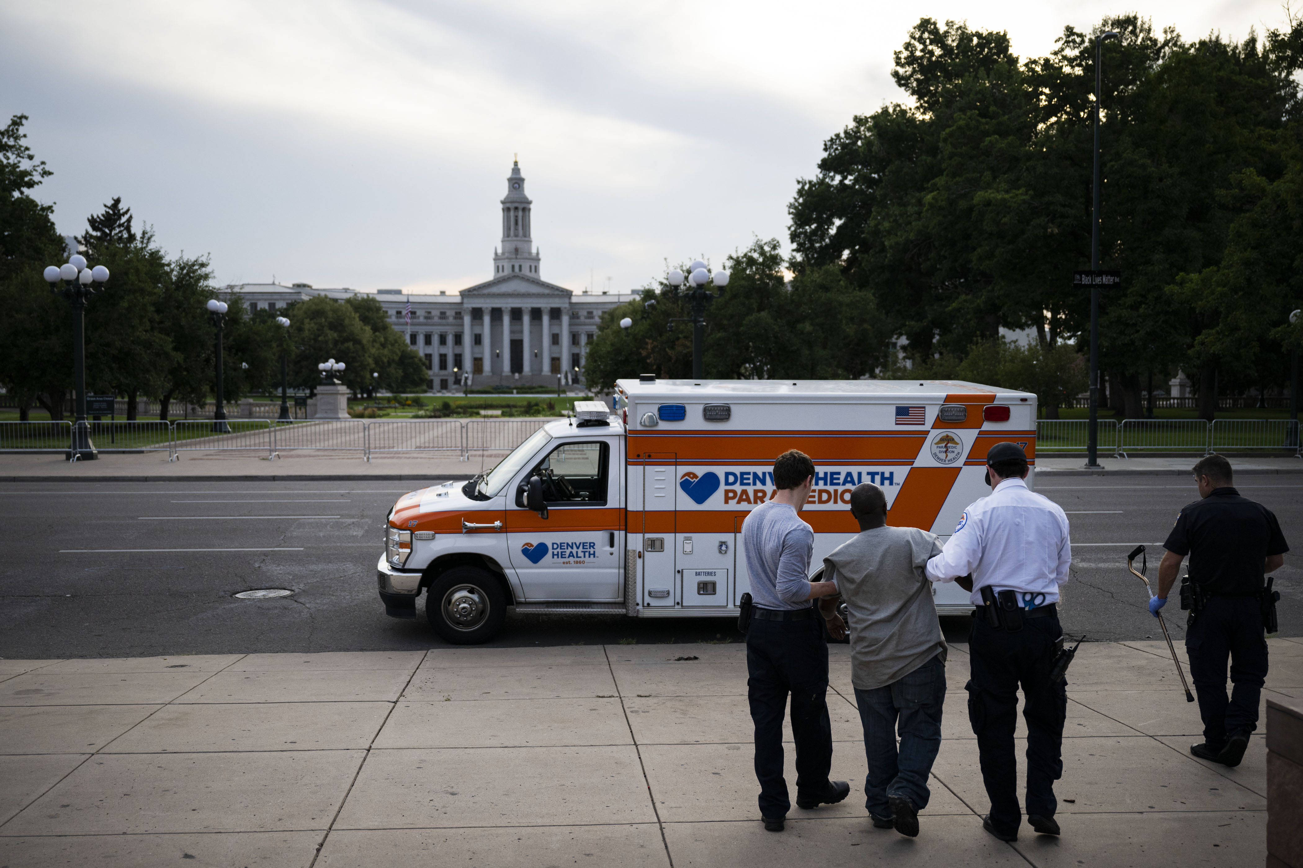 Denver Health paramedics and a Colorado State Trooper help a patient to their ambulance to be transported to a nearby hospital on Wednesday, July 27, 2022, in Denver, Colo.(Timothy Hurst/The Denver Gazette) (TimHursttim.hurst@gazette.comhttps://secure.gravatar.com/avatar/aca82bd62b4ee425c598527cd6faa1b1?d=mm&r=g)