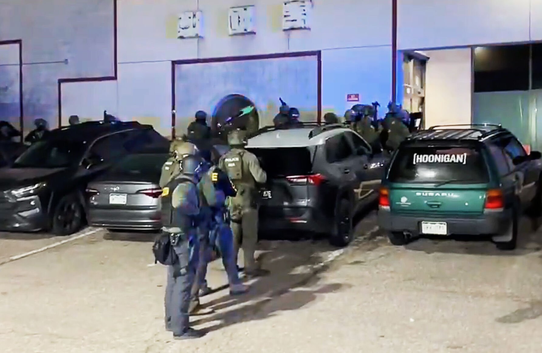 Law enforcement officers from federal and local agencies get ready to raid an underground nightclub early Sunday morning. Over 100 undocumented immigrants were detained after the drug and prostitution raid. Screenshot take from DEA video