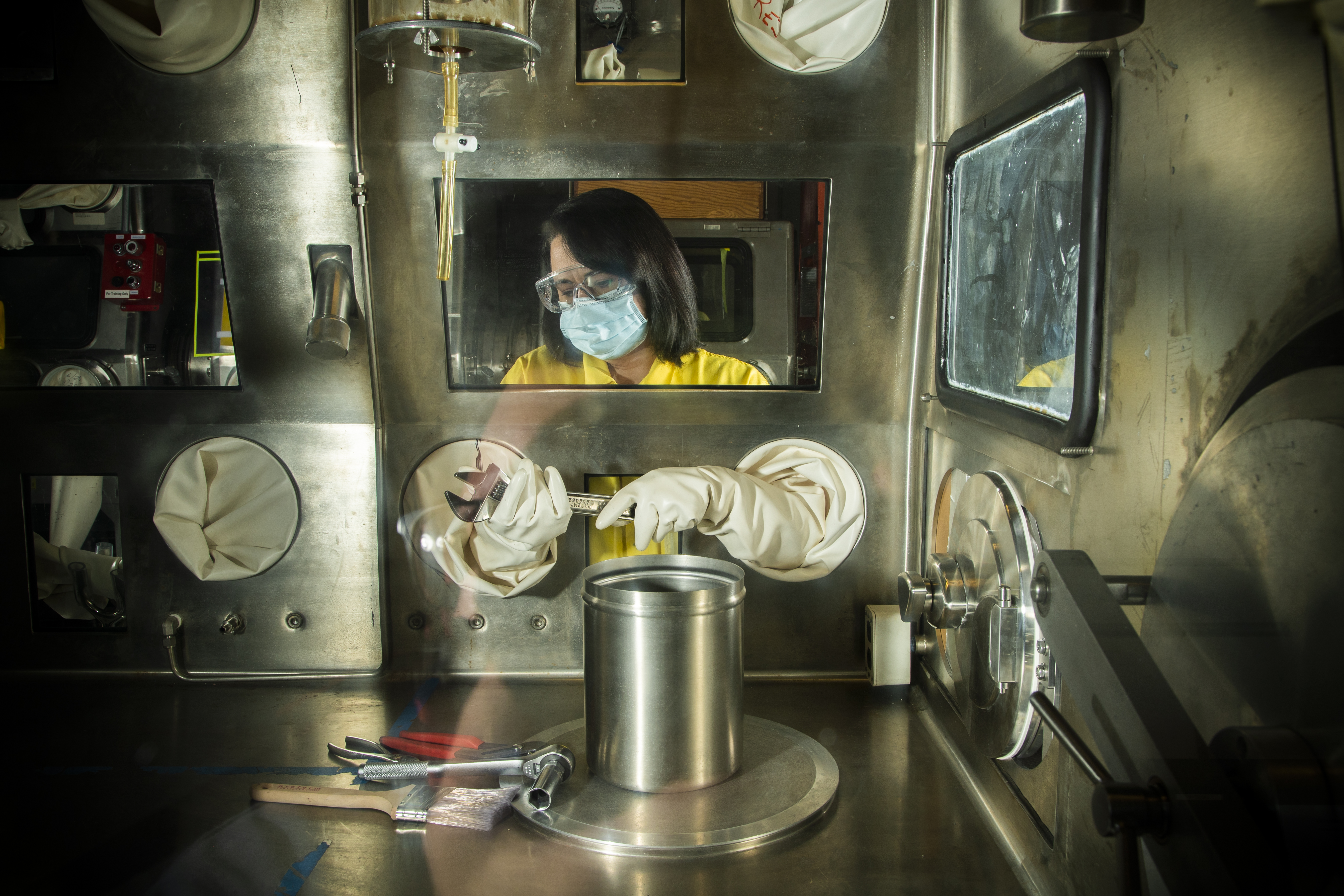 Radiological Control Technicians simulate work processes in a glove box training facility. (Carlos Trujillo)