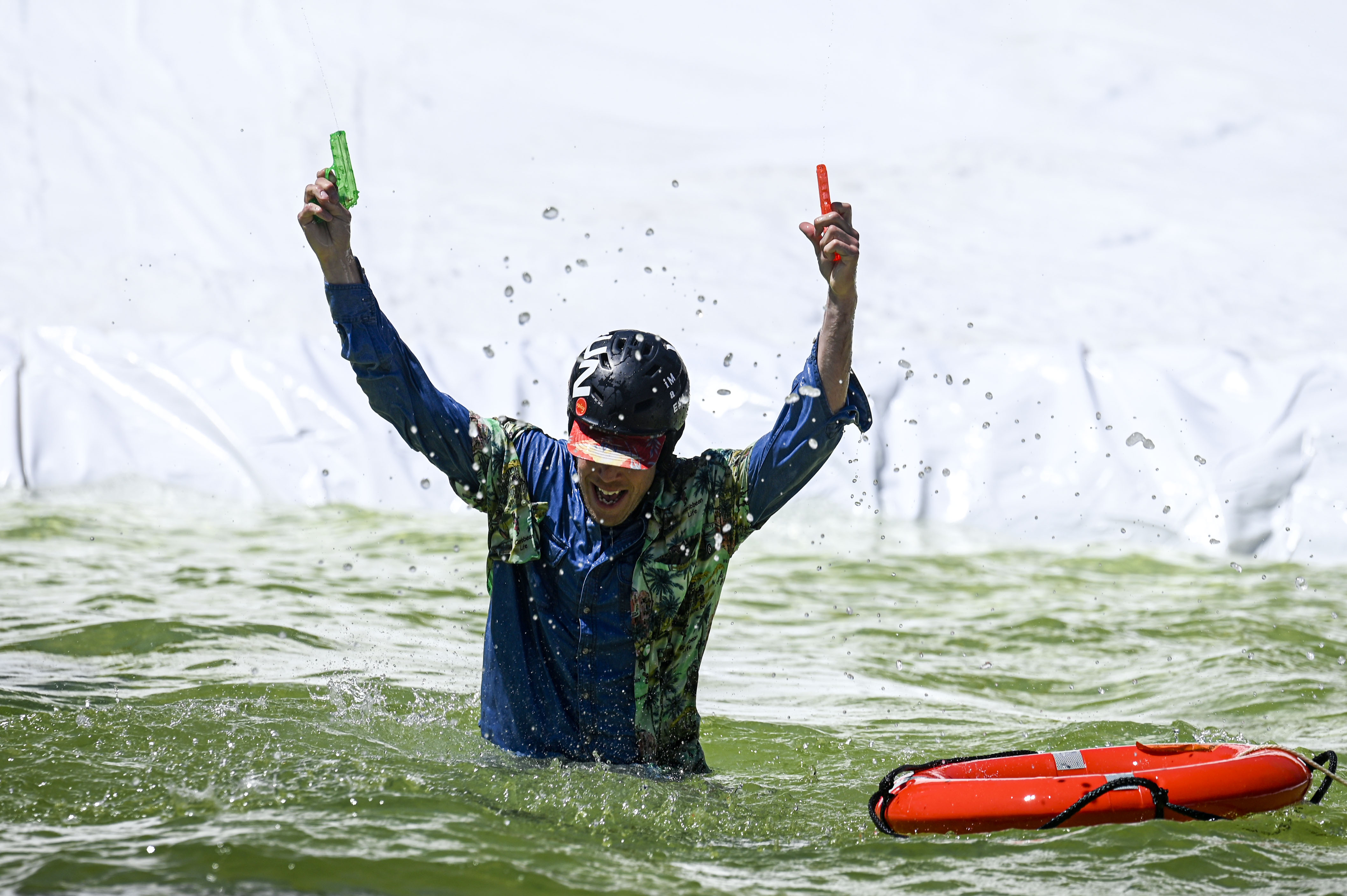 A competitor fires water guns in the air after falling into a pool of water at the base of Winter Park during the Spring Splash event to celebrate the last day of the season on Sunday, April 27, 2025 (Stephen Swofford, Denver Gazette) (StephenSwoffordPhotographerstephen.swofford@gazette.comhttps://secure.gravatar.com/avatar/1ddcaf11c5d70eaa58546ddc4e038687?d=mm&r=g)