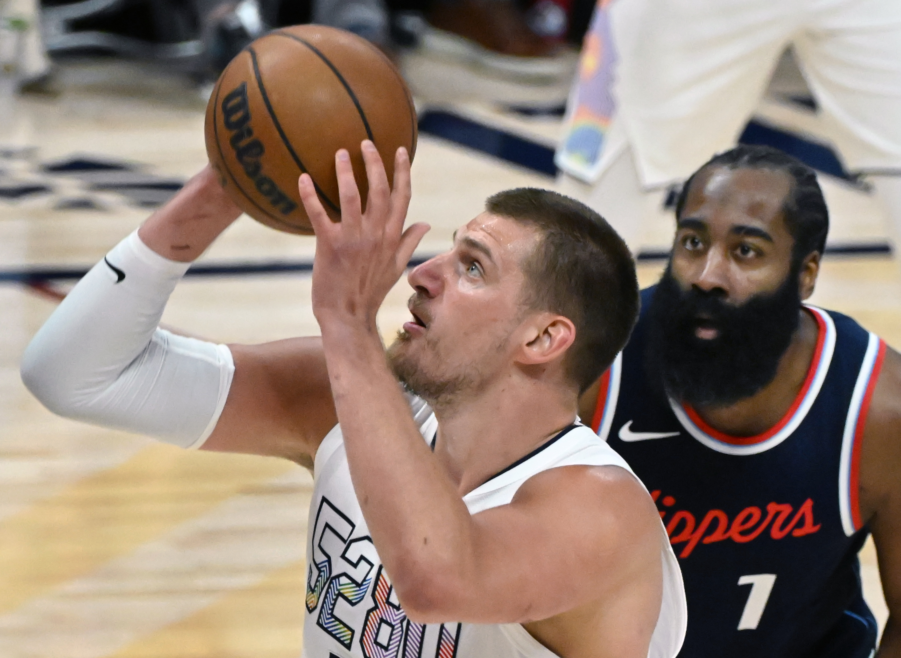 Denver Nuggets center Nikola Jokic (15) shoots the ball while LA Clippers guard James Harden (1) keeps an eye from behind during the 1st quarter of game 5 of the first round of the Western Championships at Ball Arena on Tuesday, April 29, 2025. (Jerilee Bennett,The Gazette)