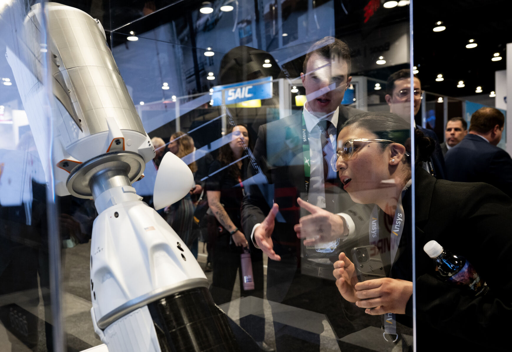 Marsha Dubon, right, reacts as Tristan Prejean, an employee at Vast, gives her details about the Haven-1 space station model at the 39th Space Symposium at The Broadmoor in 2024. (Parker Seibold, the denver gazette file)