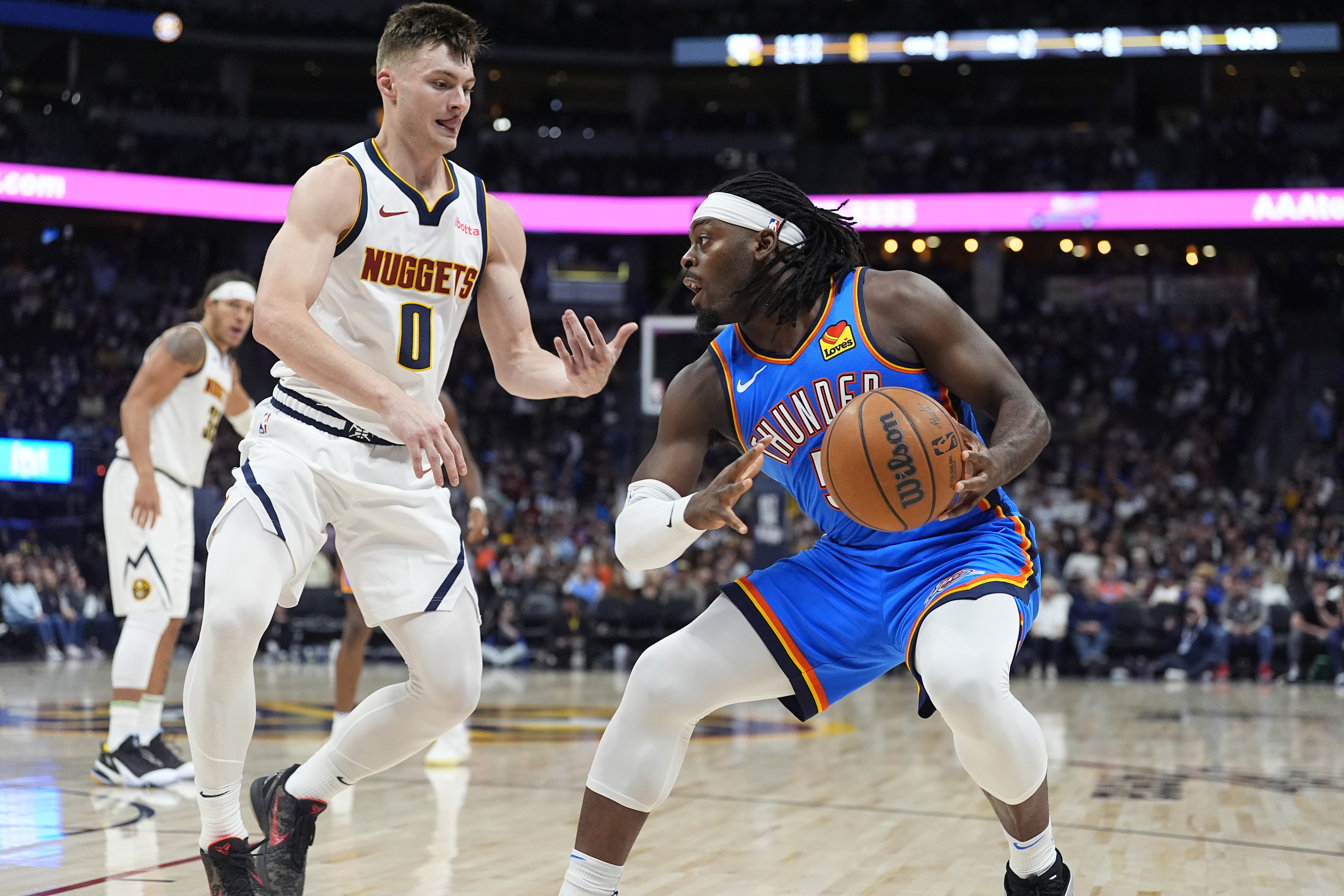 Oklahoma City Thunder guard Luguentz Dort (5) and Denver Nuggets guard Christian Braun (0) in the second half of an NBA basketball game Thursday, Oct. 24, 2024, in Denver. (AP Photo/David Zalubowski) (David Zalubowski)