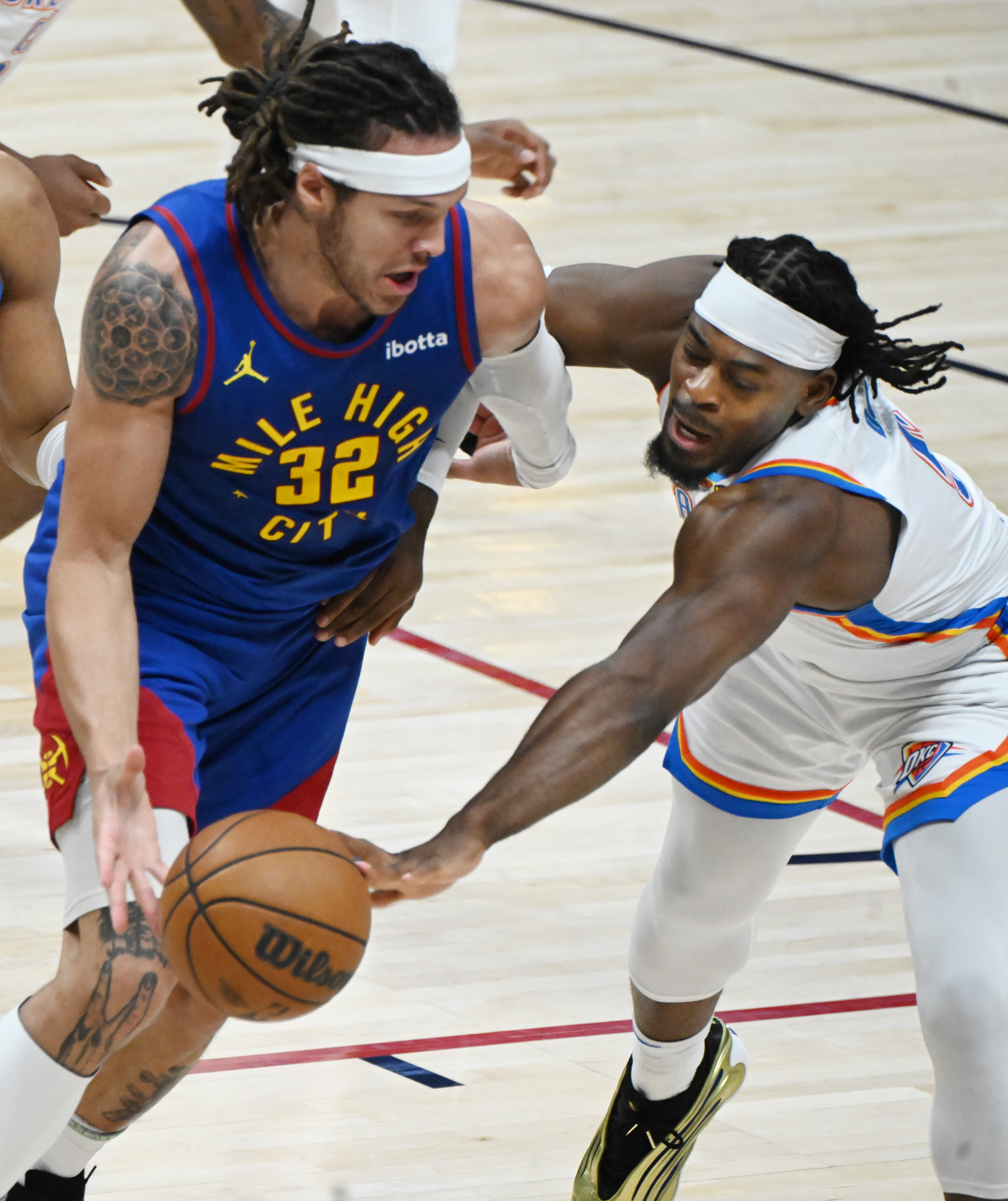 Oklahoma City Thunder guard Luguentz Dort (5) challenges Denver Nuggets forward Aaron Gordon (32) for the ball during the 2nd quarter of game 3 of round 2 of the Western Conference Championship at Ball Arena on Friday, May 9, 2025. (Jerilee Bennett,The Gazette)