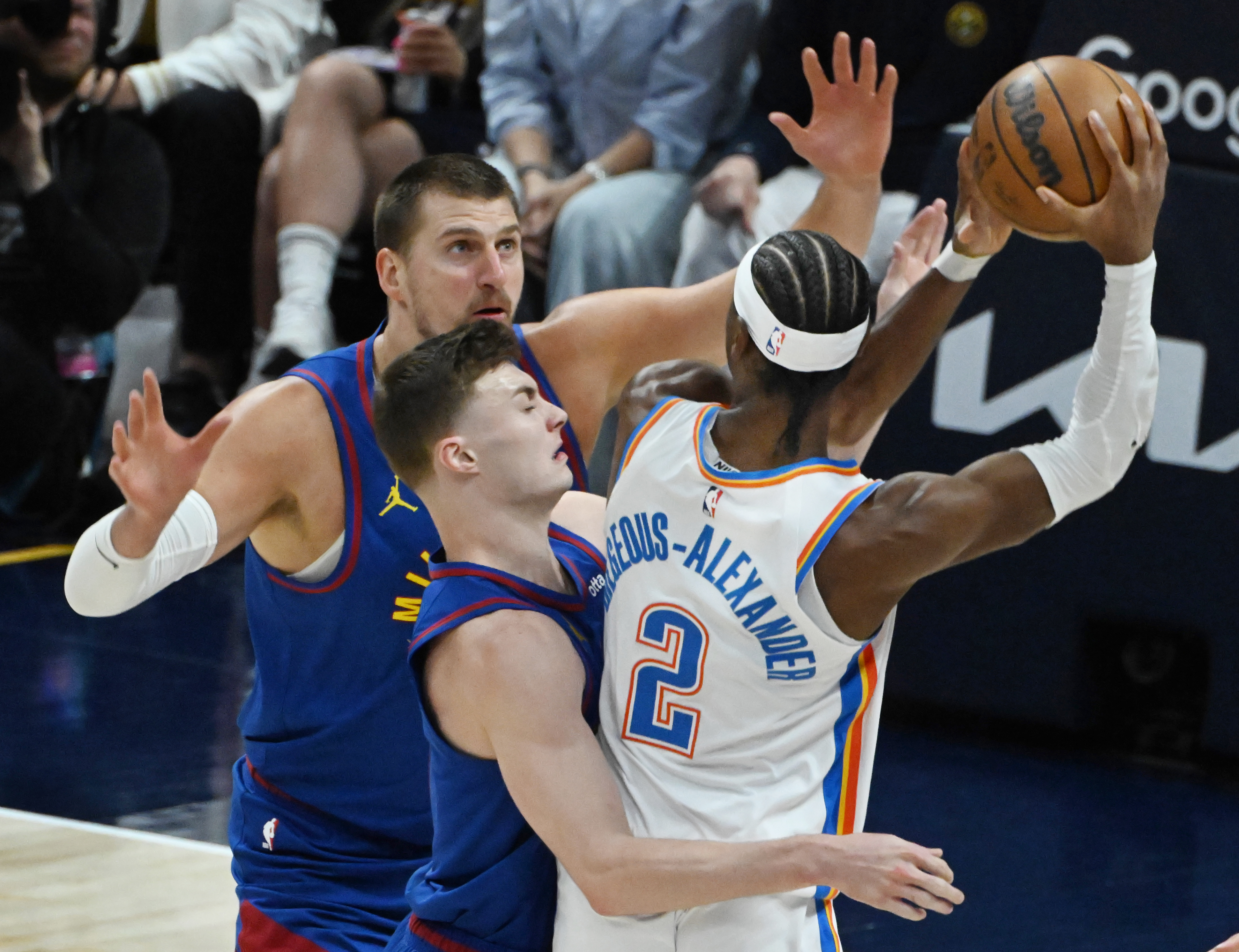 Denver Nuggets center Nikola Jokic (15) and Denver Nuggets guard Christian Braun (0) defend Oklahoma City Thunder guard Shai Gilgeous-Alexander (2) as he tries to pass the ball during the first quarter of game 3 of round 2 of the Western Conference Championship at Ball Arena on Friday, May 9, 2025. (Jerilee Bennett,The Gazette)