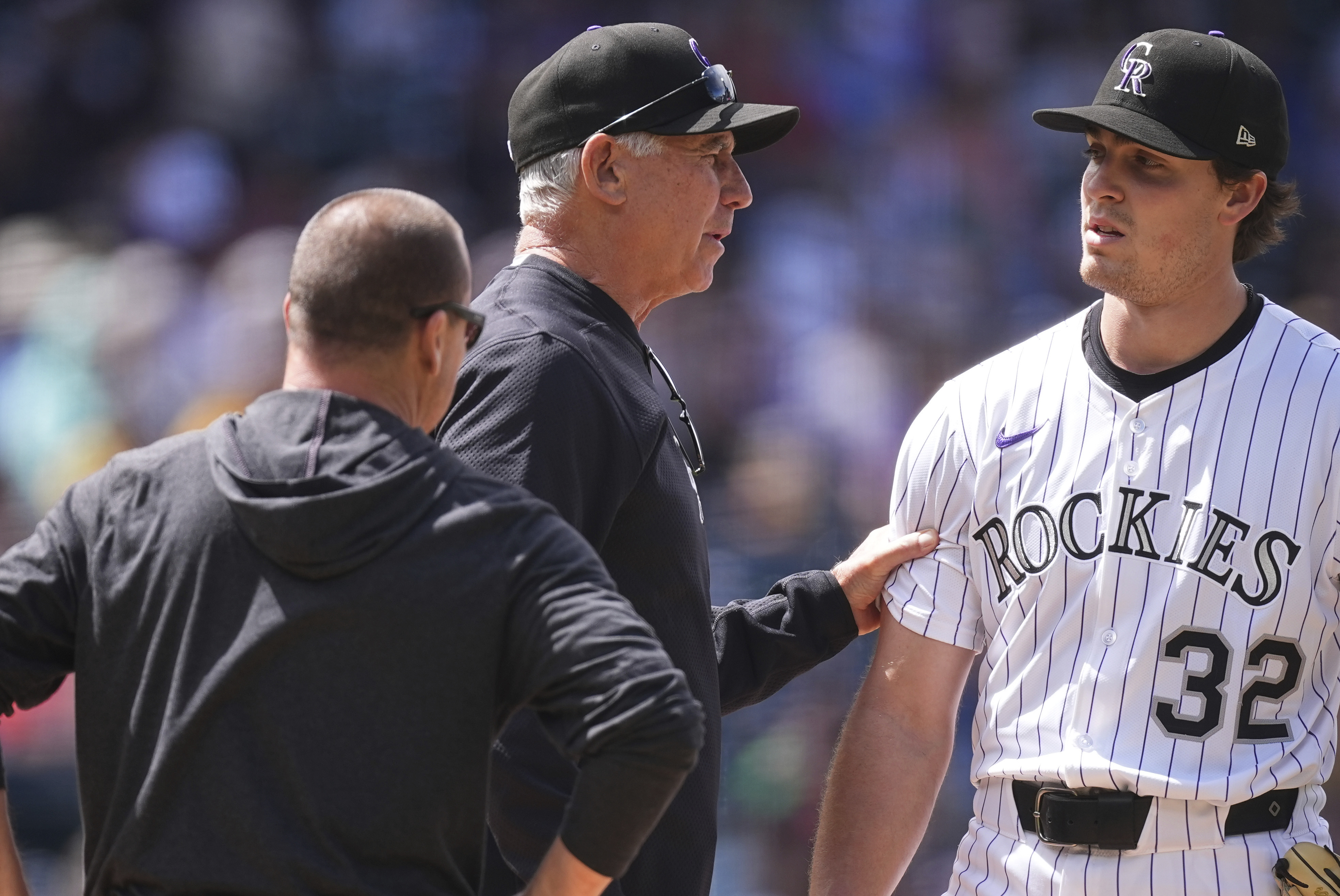 As trainer Heath Townsend, left, looks on, Colorado Rockies manager Bud Black (10) confers with starting pitcher Chase Dollander (32) as he leaves the mound in the sixth inning of a baseball game Wednesday, April 30, 2025, in Denver. (AP Photo/David Zalubowski) (David Zalubowski)