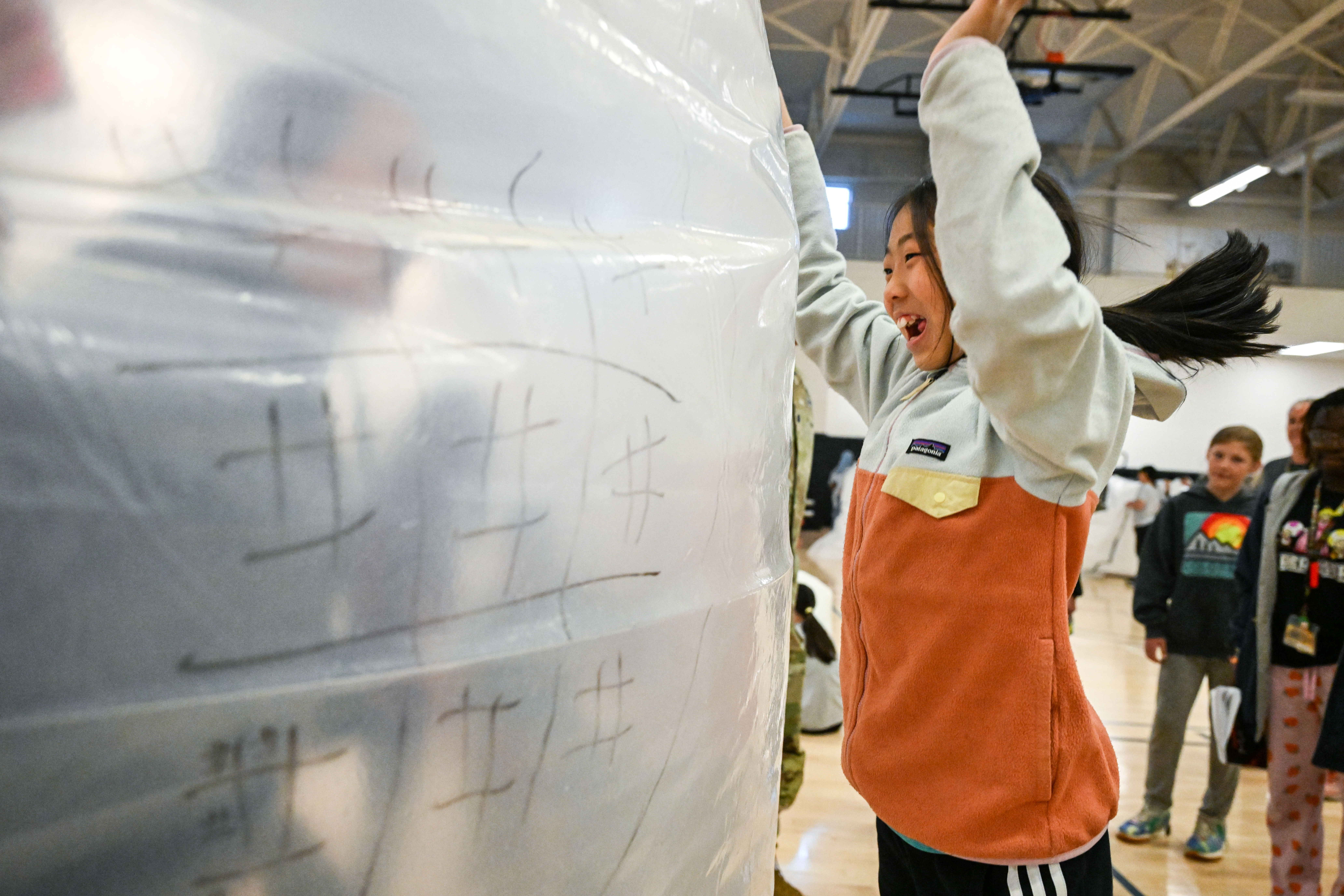 A Student from Quest Elementary interacts with her teacher through the wall of a Mars habitat they built at Buckley Space Force Base as part of the school liaison program. Elementary schools from the area came to the base to build habitats, create life support systems, and complete Mars facts puzzles as part of a Mission to Mars event on Tuesday, May 6, 2025. (Stephen Swofford, Denver Gazette) (StephenSwoffordPhotographerstephen.swofford@gazette.comhttps://secure.gravatar.com/avatar/1ddcaf11c5d70eaa58546ddc4e038687?d=mm&r=g)