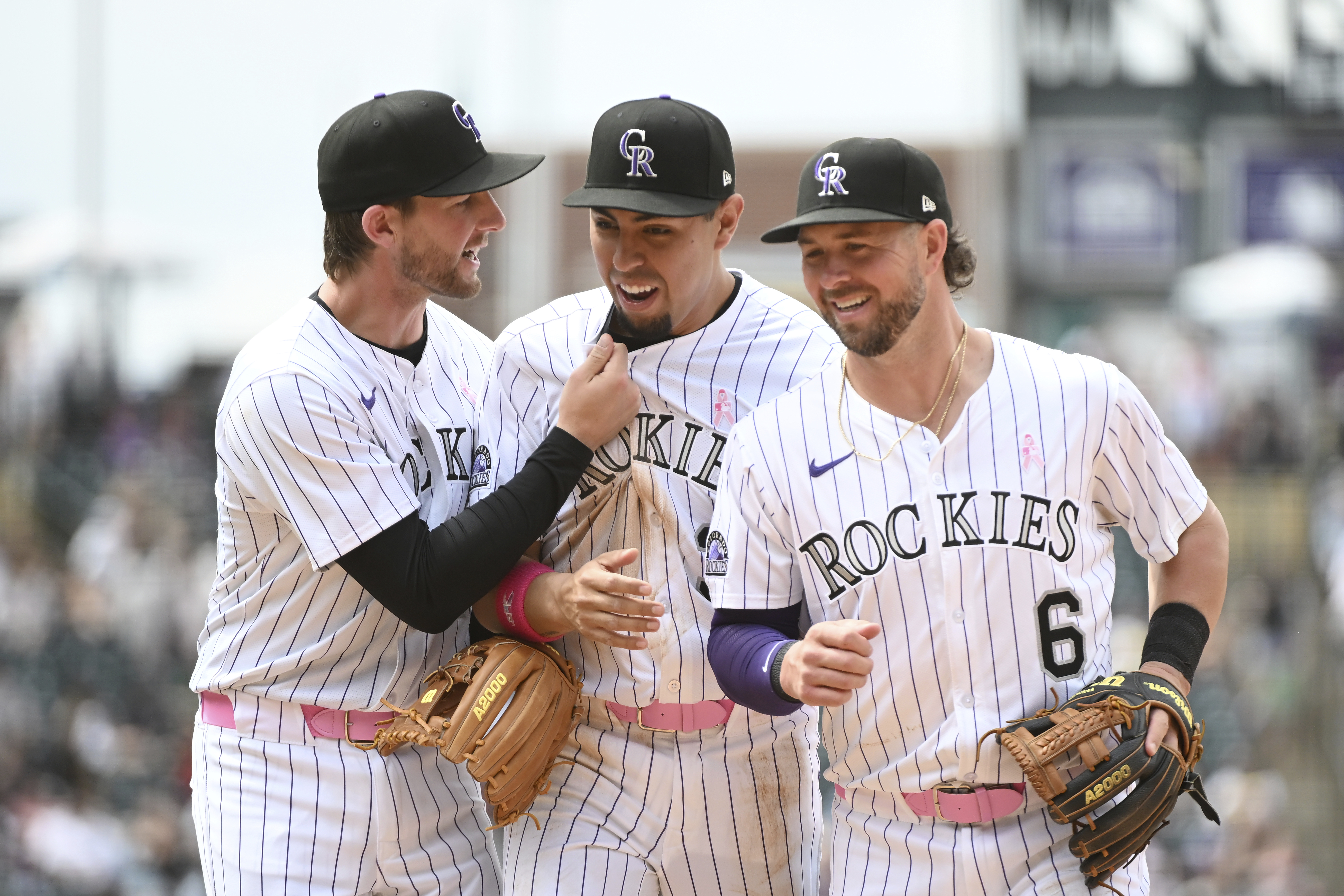 From left to right, Colorado Rockies third baseman Ryan McMahon, shortstop Alan Trejo and second baseman Kyle Farmer celebrate after a double play in the seventh inning of a baseball game against the San Diego Padres, Sunday, May 11, 2025, in Denver. (AP Photo/Geneva Heffernan) (Geneva Heffernan)