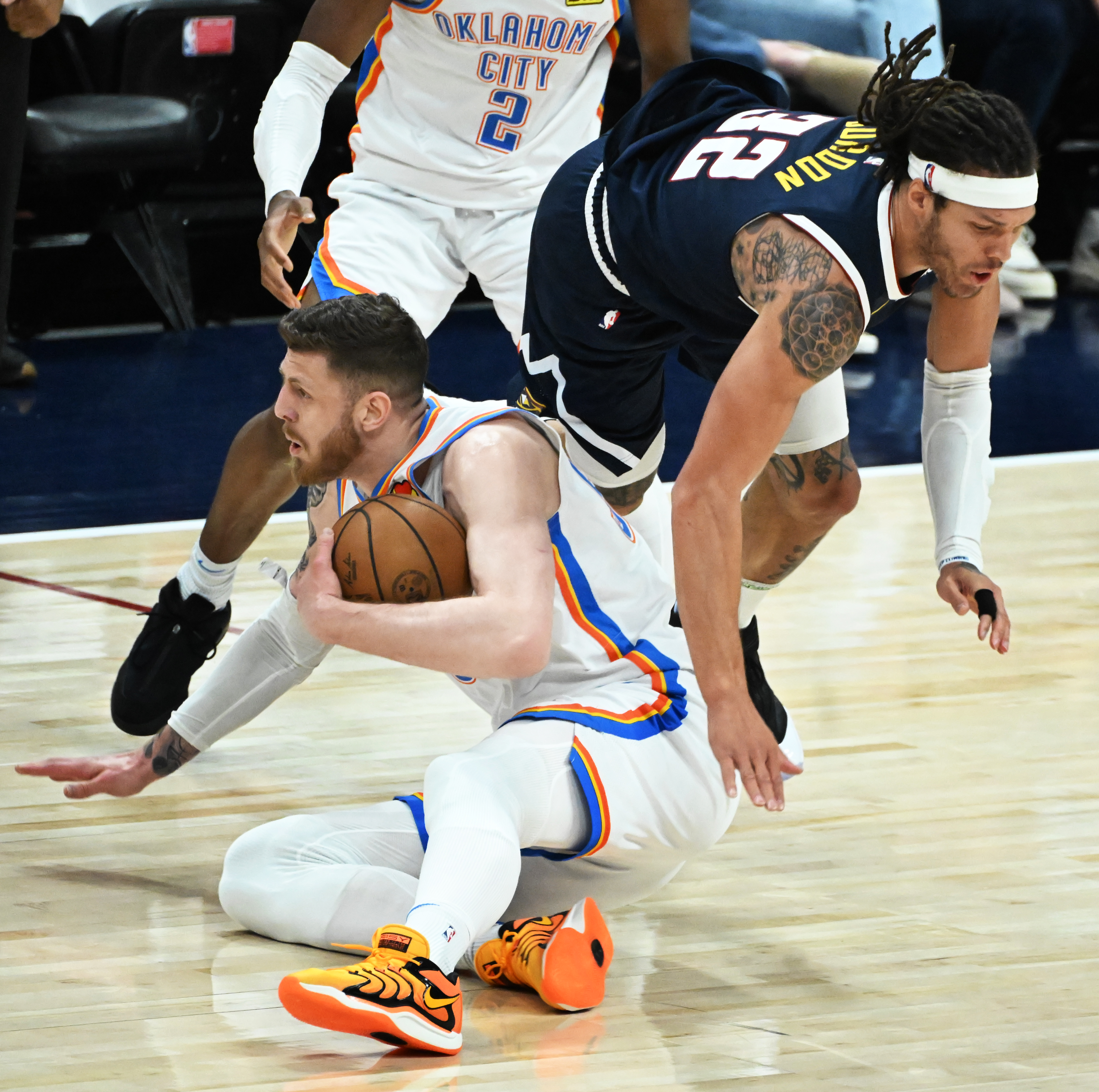 Denver Nuggets forward Aaron Gordon (32) gets upended while going for a loose ball with Oklahoma City Thunder center Isaiah Hartenstein (55) during the 1st quarter of game 4 of the second round of the Western Conference Championship at Ball Arena on Sunday, May 11, 2025. (Jerilee Bennett,The Gazette)