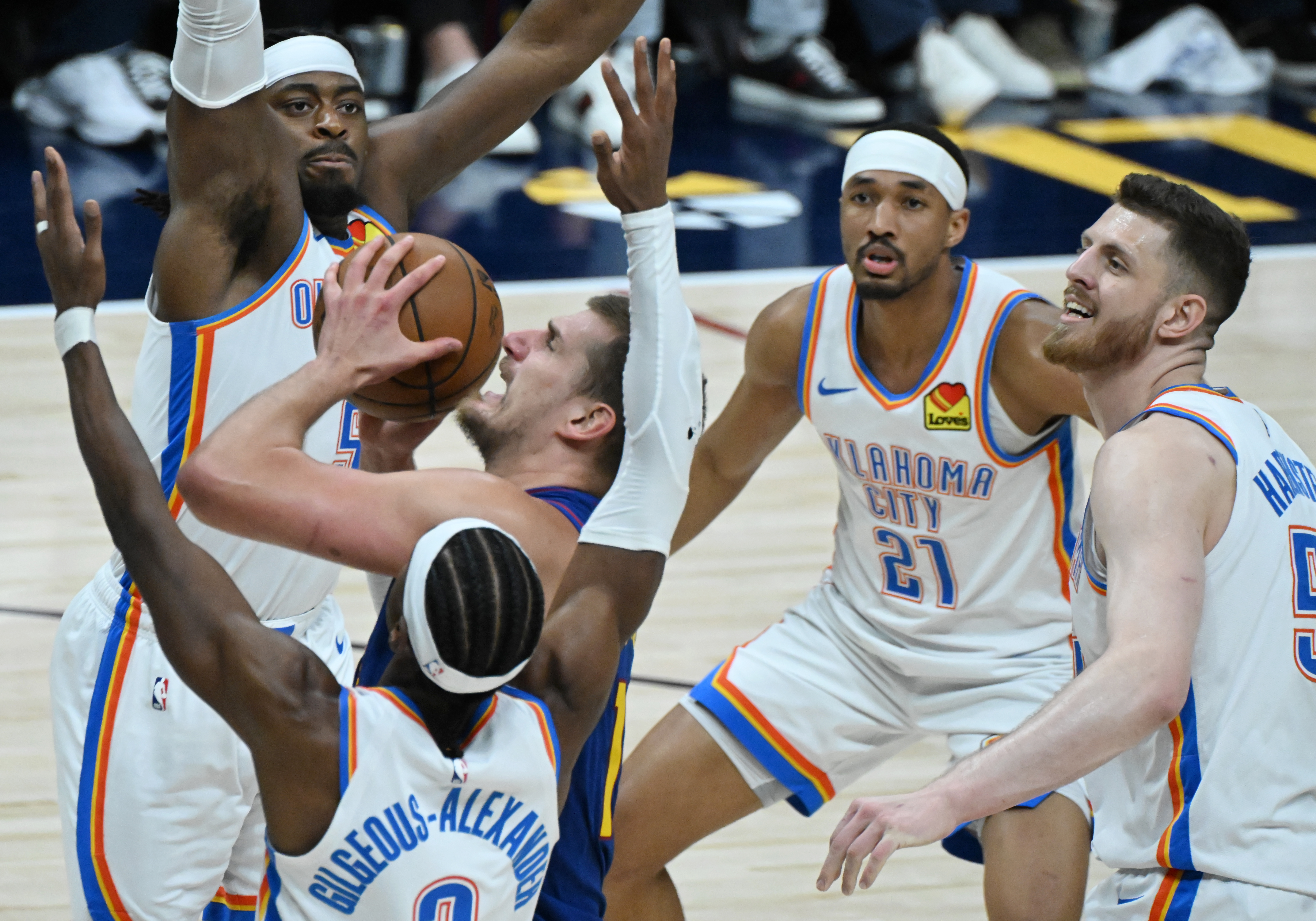 Denver Nuggets center Nikola Jokic (15) is surrounded by Oklahoma City Thunder guard Luguentz Dort (5), Oklahoma City Thunder guard Shai Gilgeous-Alexander (2), Oklahoma City Thunder guard Aaron Wiggins (21) and Oklahoma City Thunder center Isaiah Hartenstein (55) during the 2nd quarter of game 3 of round 2 of the Western Conference Championship at Ball Arena on Friday, May 9, 2025. (Jerilee Bennett,The Gazette)