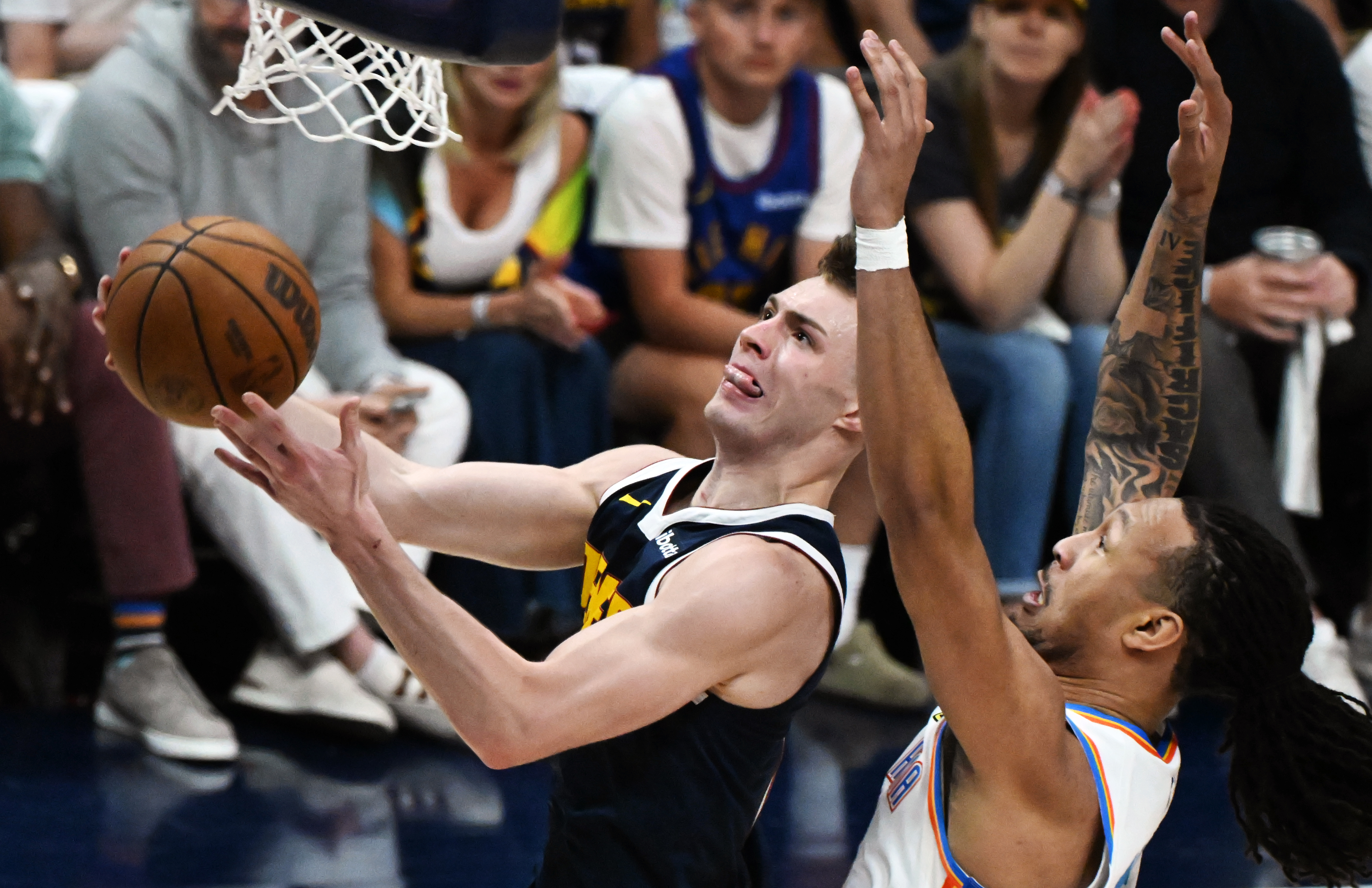 Denver Nuggets guard Christian Braun (0) goes for layup over Oklahoma City Thunder forward Jaylin Williams (6) during the 2nd quarter of game 4 of the second round of the Western Conference Championship at Ball Arena on Sunday, May 11, 2025. (Jerilee Bennett,The Gazette)