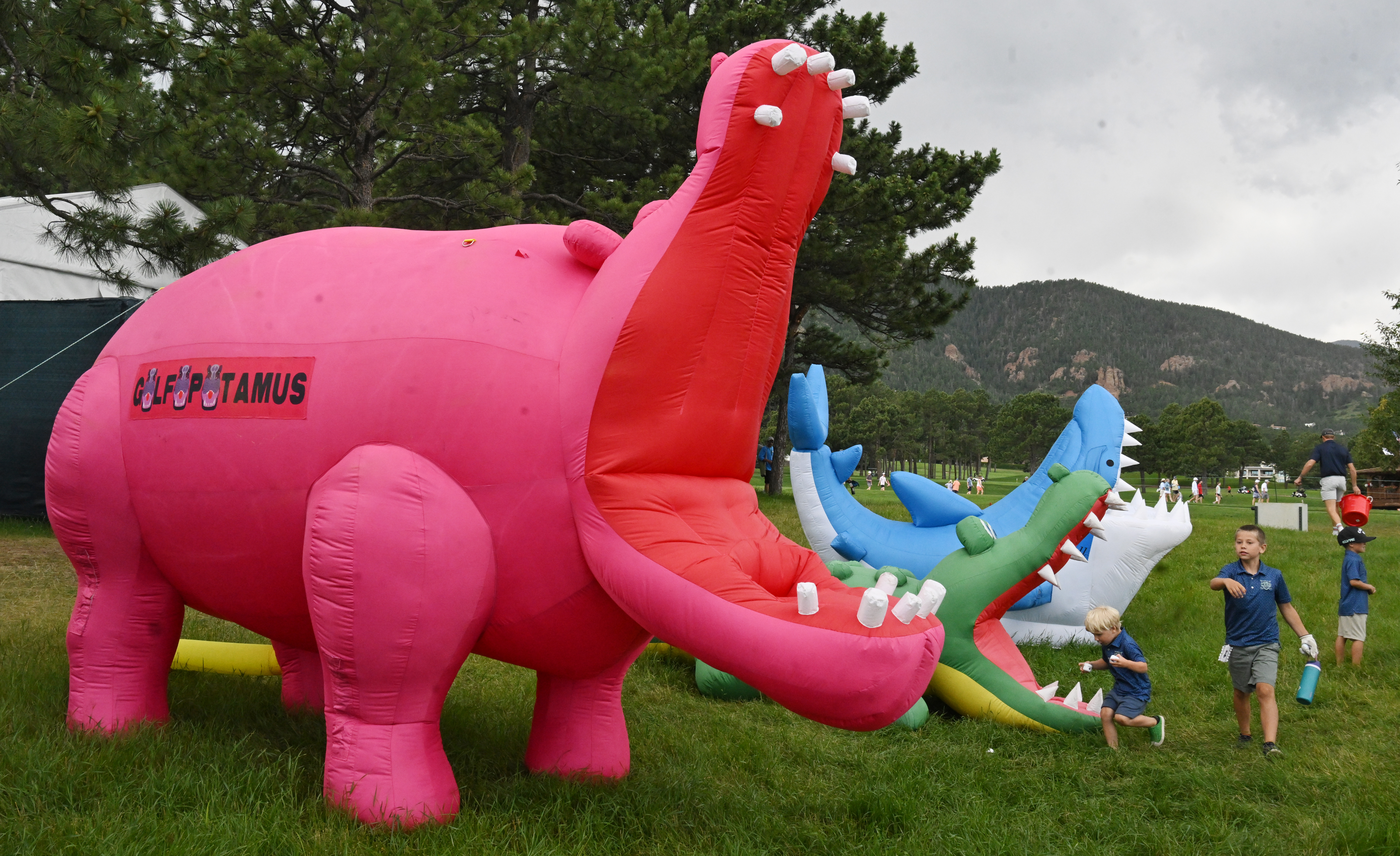 Brothers Charlie, Cooper and Henry play with some of the Golfasaurus and other inflatables in a child-themed area for those attending the U.S. Senior Open Championship at the Broadmoor Golf Club on Friday, June 27, 2025. The area is located between Holes 16 and 17. (Jerilee Bennett,The Gazette)