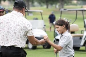 Mark Romero hands Ziba Espino a golf tee