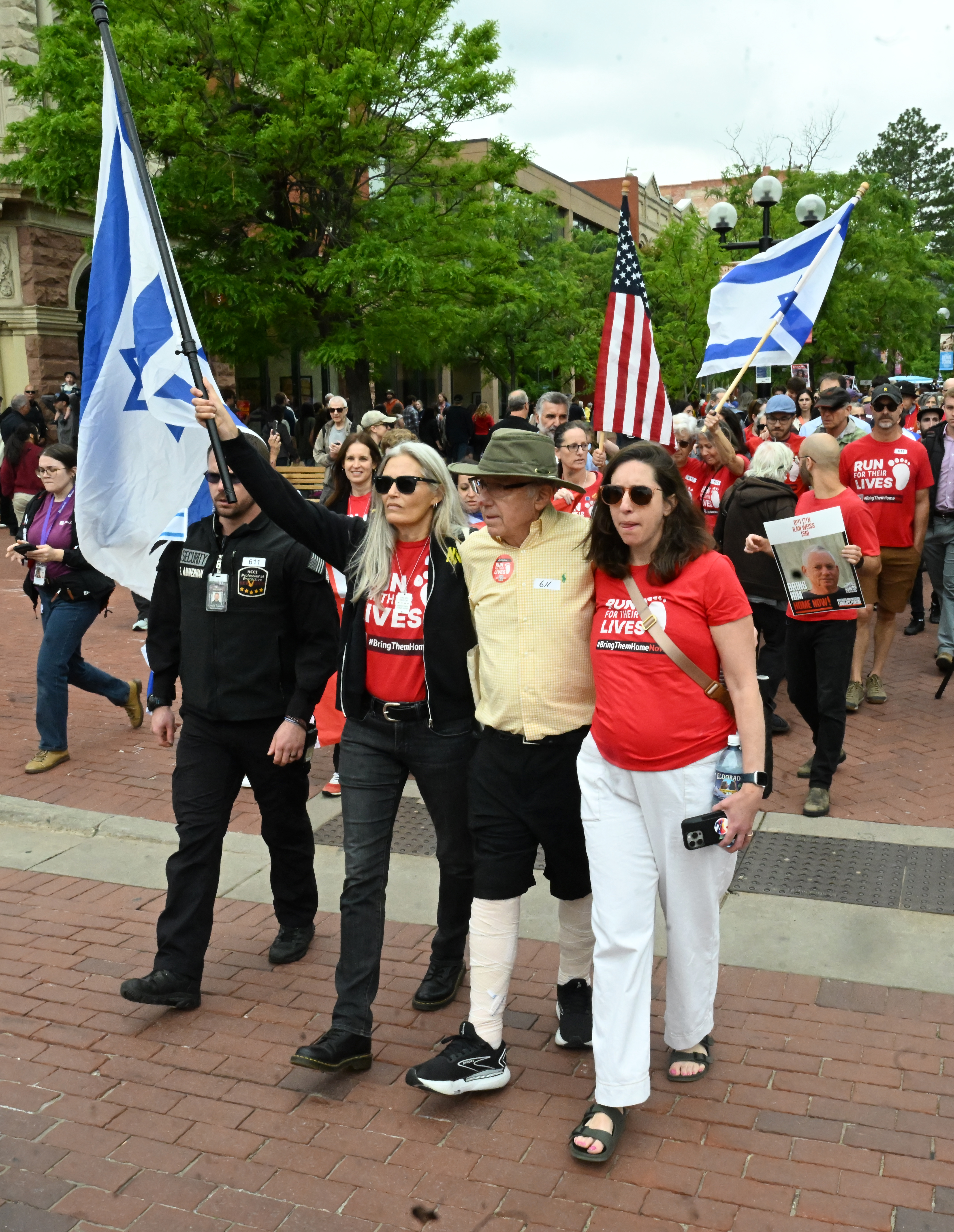 Rachel Amaru, co-lead of the Boulder Run for Their Lives Chapter (left), walks arms in arm with a man with bandaged legs and arm, who asked not to be named, during a the Run for Their Lives walk to show resilience and solidarity in the face of the June 1 antisemitic terror attack on the Pearl Street Mall. They were walking in Boulder in the same location on Sunday, June 8, 2025.. The walk has been held every week in cities around the country to make sure that the hostages in Gaza, that were taken on Oct. 7, 2023, are not forgotten.