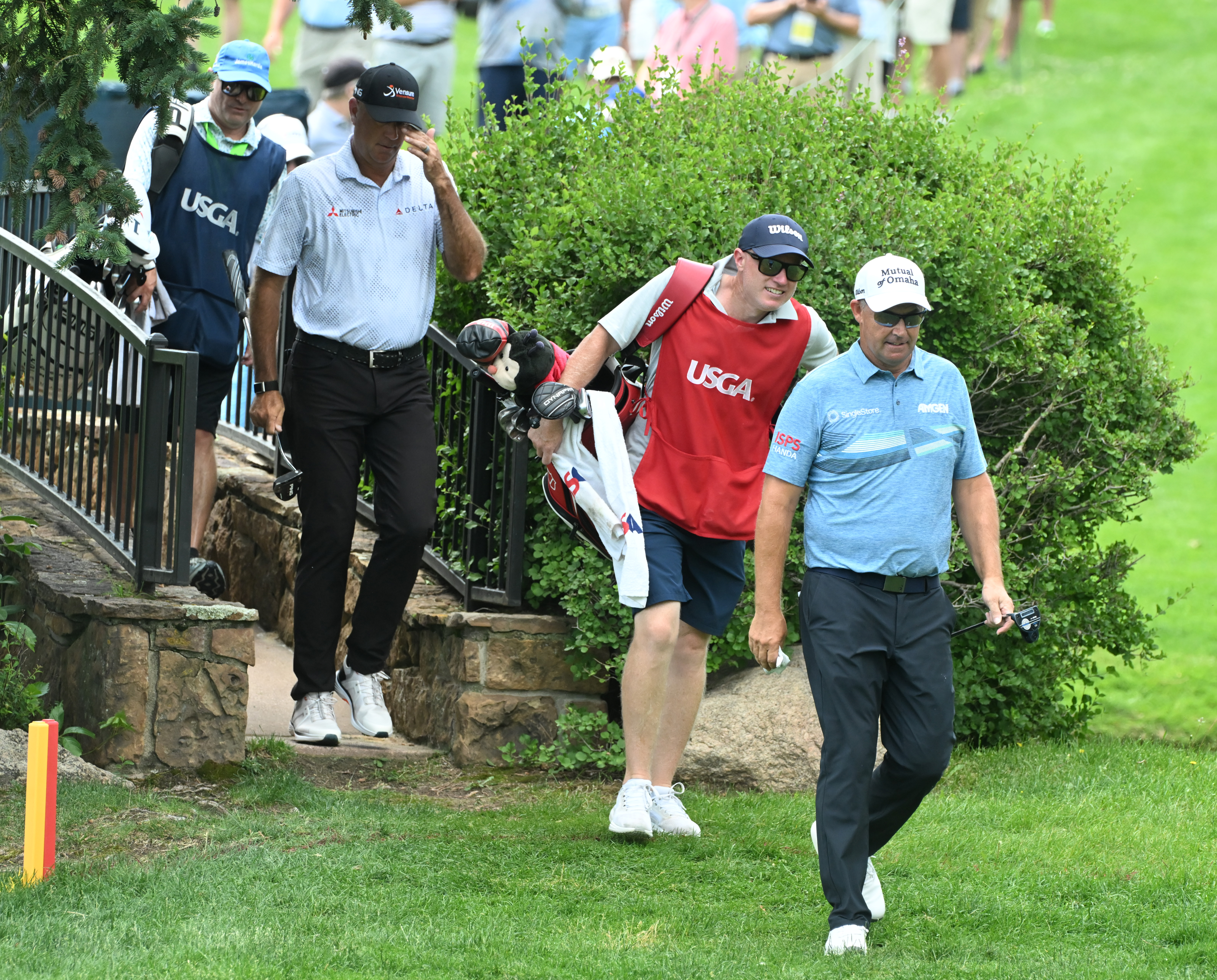 Stewart Cink (back) and Padraig Harrington (front) head over a bridge to Hole 3 with their caddies at the U.S. Senior Open Championship at the Broadmoor Golf Club on Friday, June 27, 2025. This was the second day of competition being held in Colorado Springs, Colorado. Halfway through the day Harrington and Cink were tied for first place at -6. (Jerilee Bennett,The Gazette)