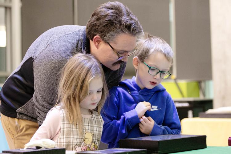 Aric Graphman and his children, Mason, 6, and Adalynn, 4, look at various animal specimens