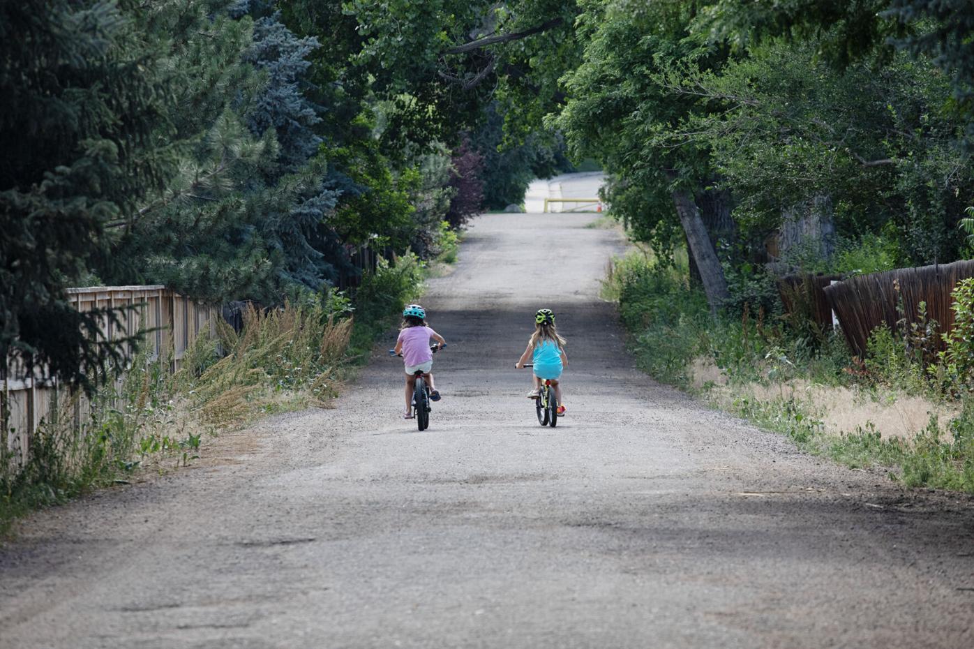Children ride their bicycles down Christensen Lane