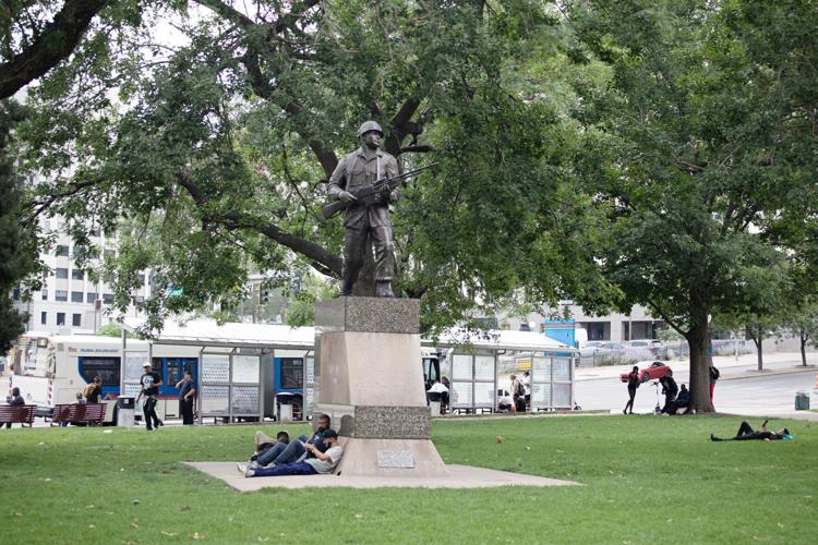 People walk and sit in Lincoln Veterans Memorial Park