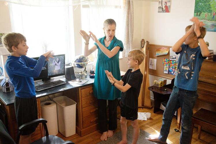 Stacie Graber sings and signs a hymn with her sons