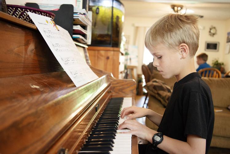 Hudson Graber plays a song on the piano during a homeschooling lesson