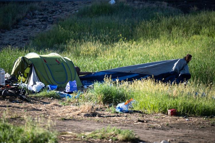 Casey Horn drags a tarp away from her encampment (copy) (copy)